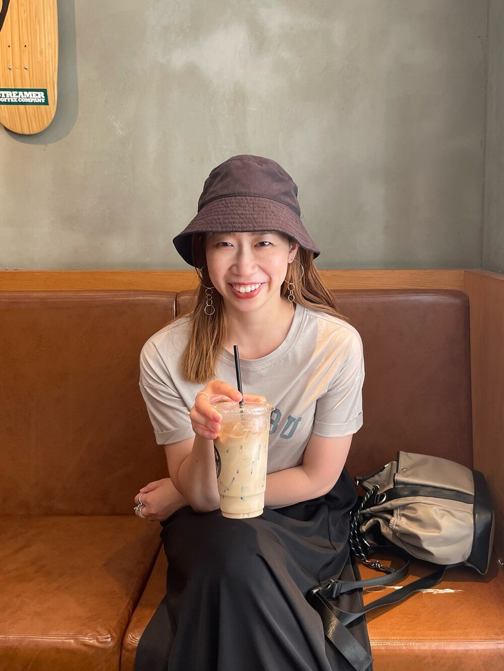 グレー系のTシャツ/カットソー、ブラック系のスカート、グレー系のバックパック/リュックを着用したレディースの夏コーディネートの3枚目の写真