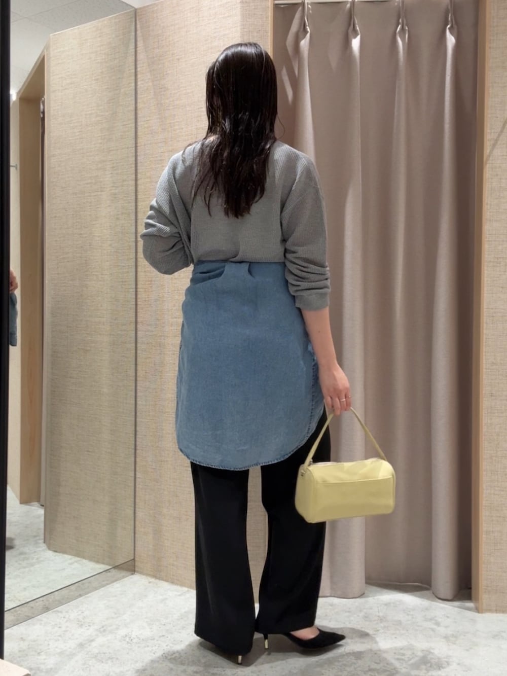 グレー系のニット/セーター、ブラック系のその他パンツ、ブルー系のシャツ/ブラウスを着用したレディースの春コーディネートの2枚目の写真