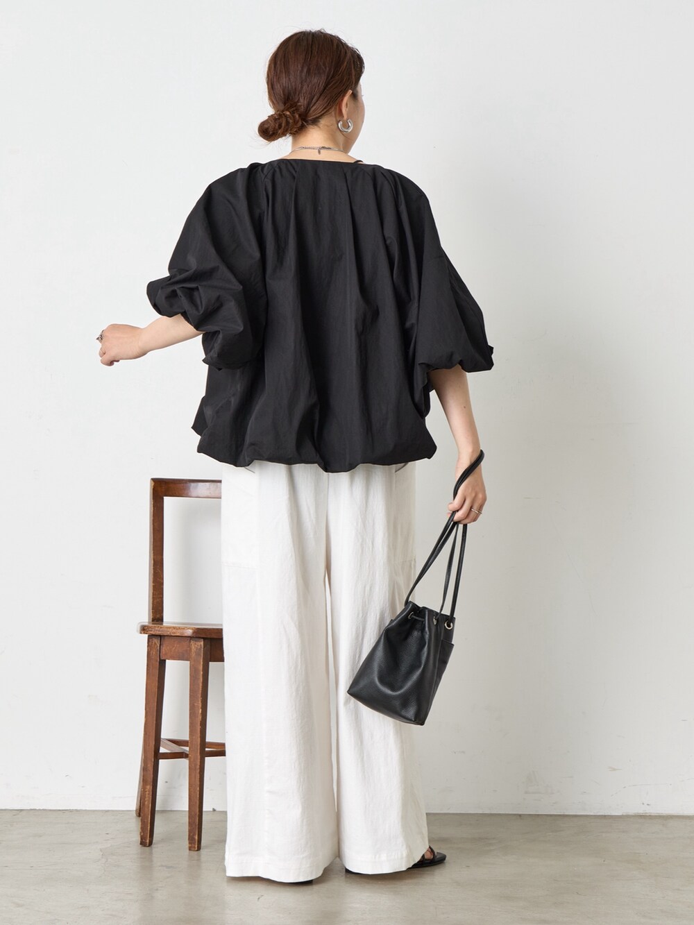 ホワイト系のワンピース、ブラック系のサンダル、ブラック系のベストを着用したレディースの夏コーディネートの3枚目の写真