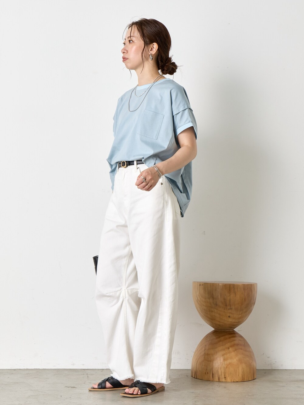 ホワイト系のデニムパンツ、ブラック系のサンダル、ブルー系のTシャツ/カットソーを着用したレディースの夏コーディネートの2枚目の写真