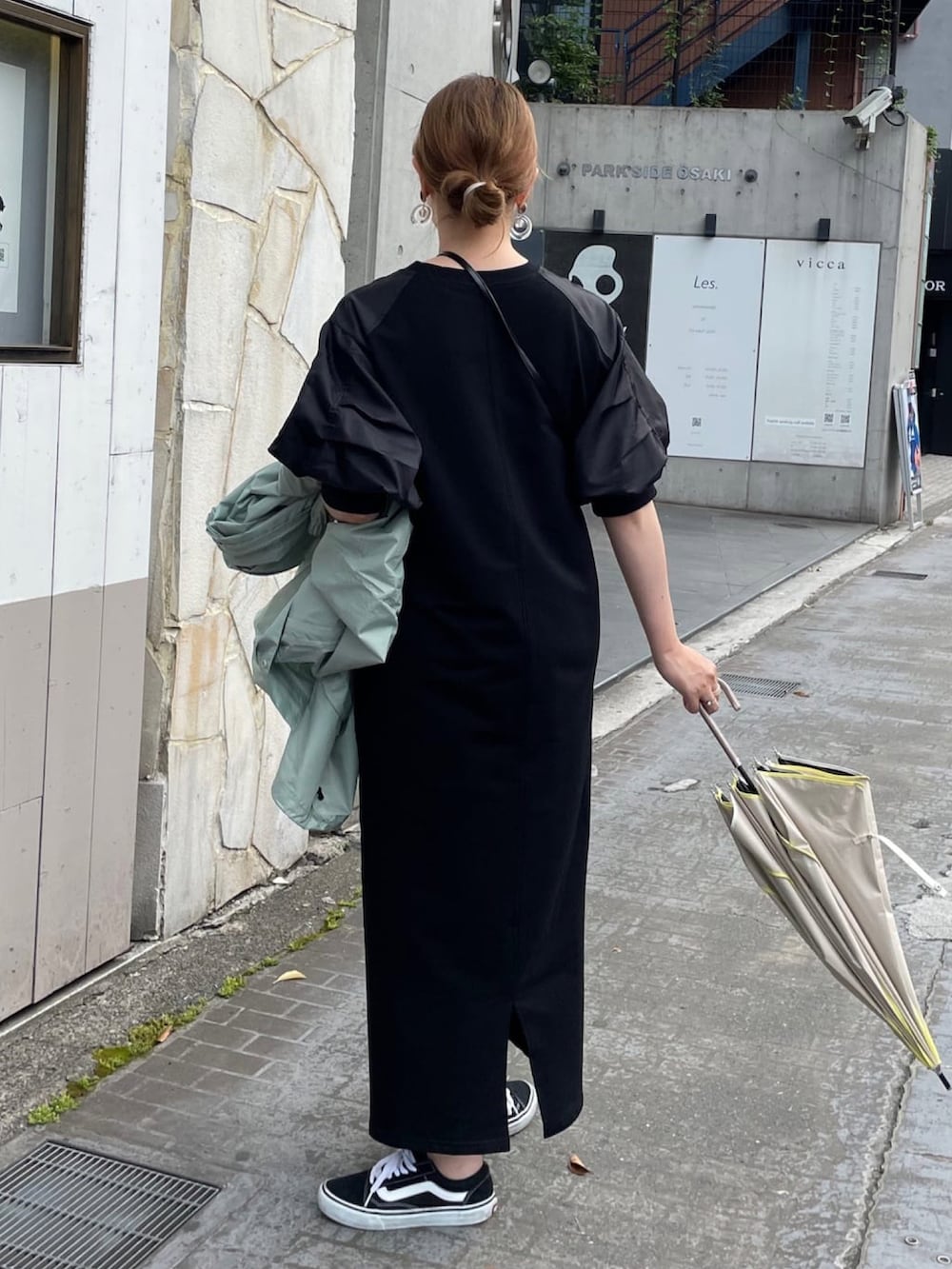 ブラック系のワンピース、ブラック系のショルダーバッグ、グリーン系のマウンテンパーカーを着用したレディースの夏コーディネートの3枚目の写真