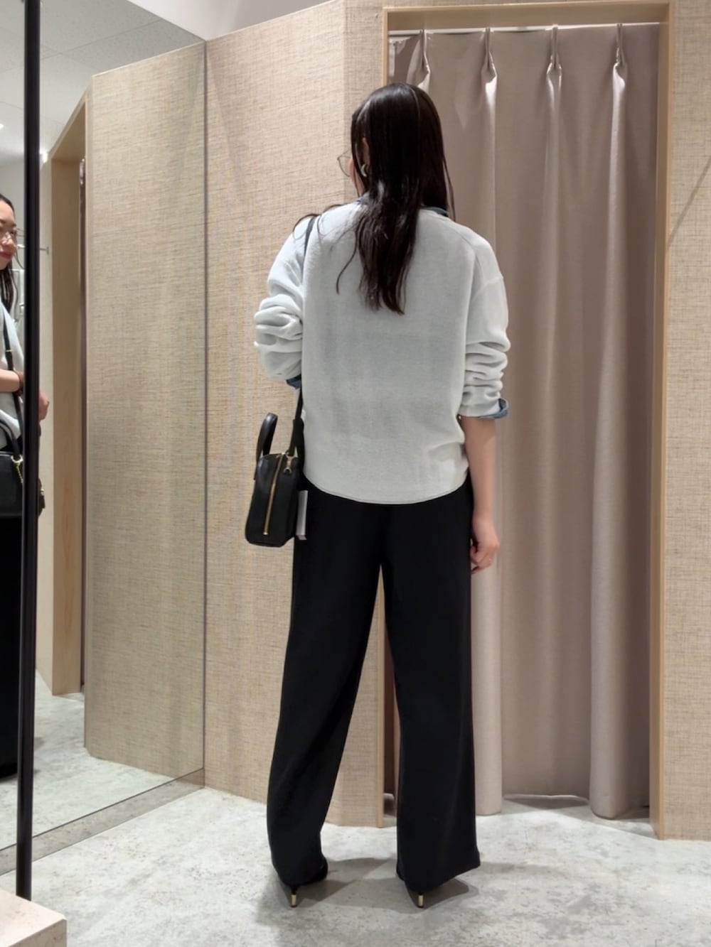 ホワイト系のニット/セーター、ブルー系のシャツ/ブラウス、ブラック系のその他パンツを着用したレディースの春コーディネートの2枚目の写真