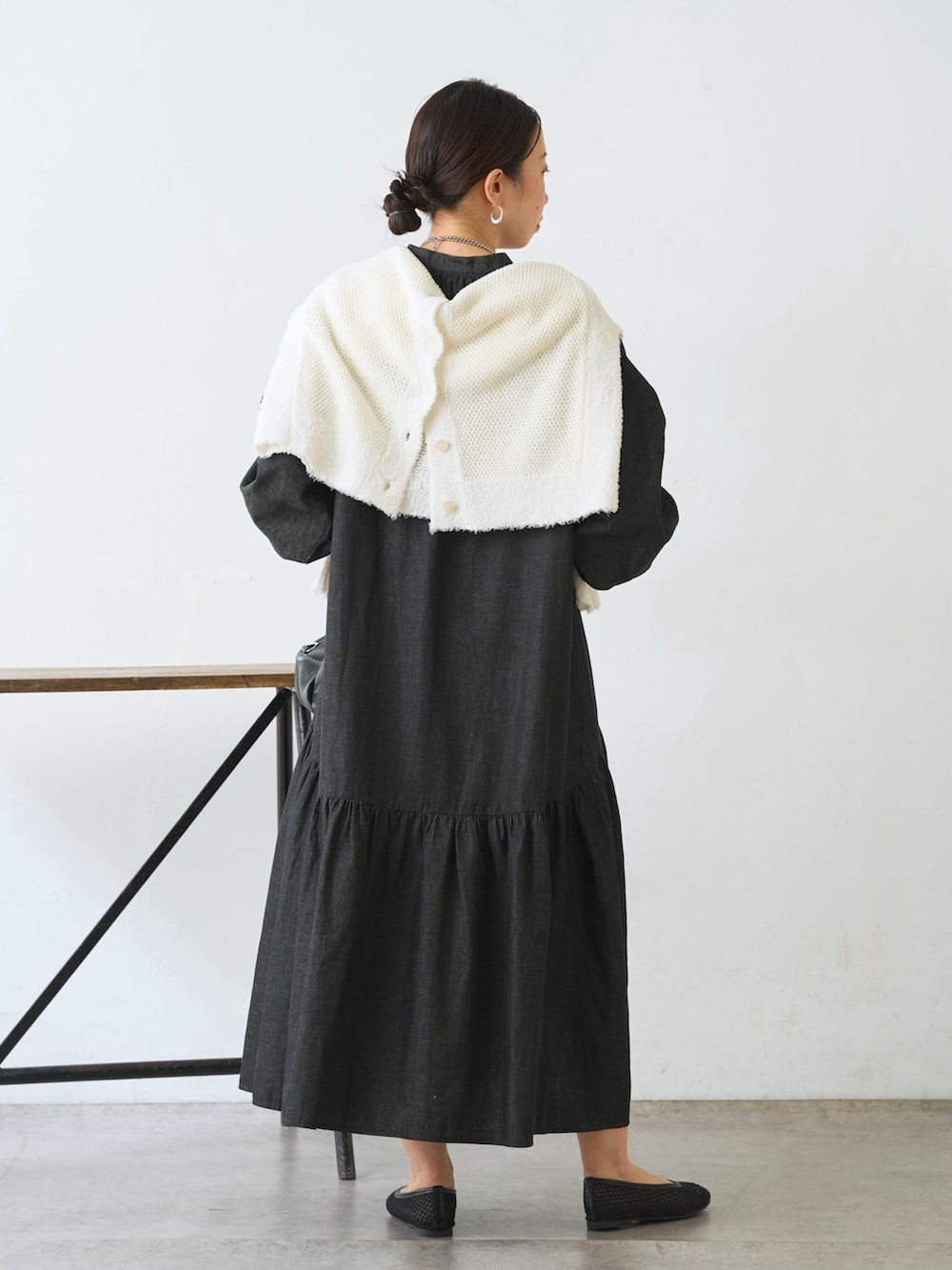 ホワイト系のカーディガン/ボレロ、ブラック系のワンピース、ブラック系のトートバッグを着用したレディースの冬コーディネートの3枚目の写真