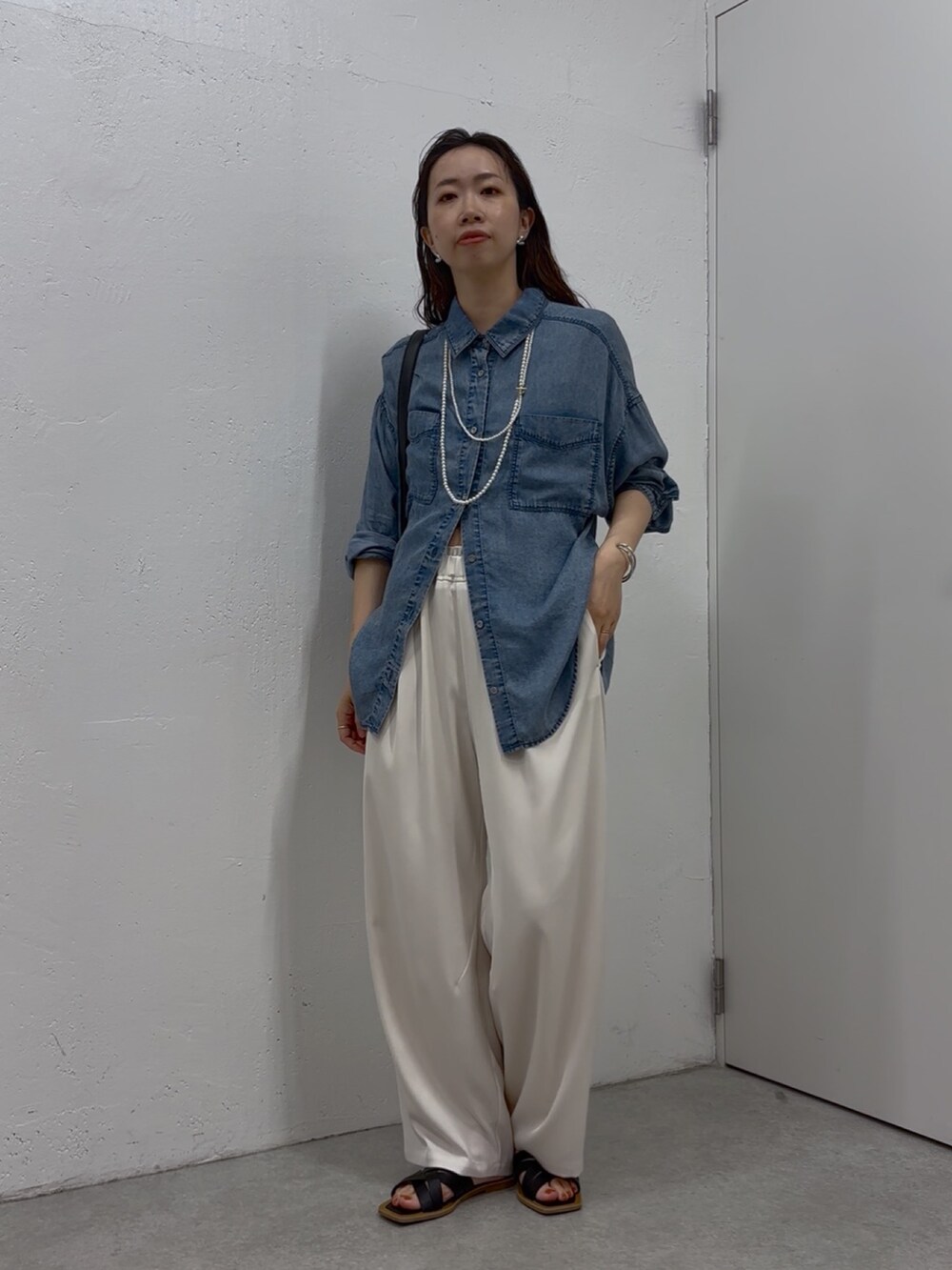 ブルー系のシャツ/ブラウス、ホワイト系のその他パンツ、ブラック系のショルダーバッグを着用したレディースの春コーディネートの3枚目の写真