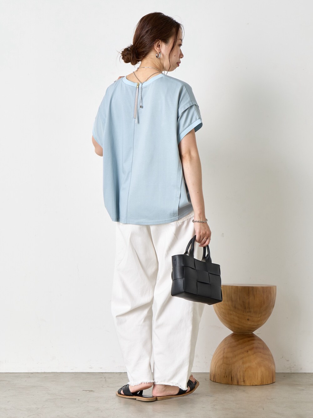 ホワイト系のデニムパンツ、ブラック系のサンダル、ブルー系のTシャツ/カットソーを着用したレディースの夏コーディネートの3枚目の写真