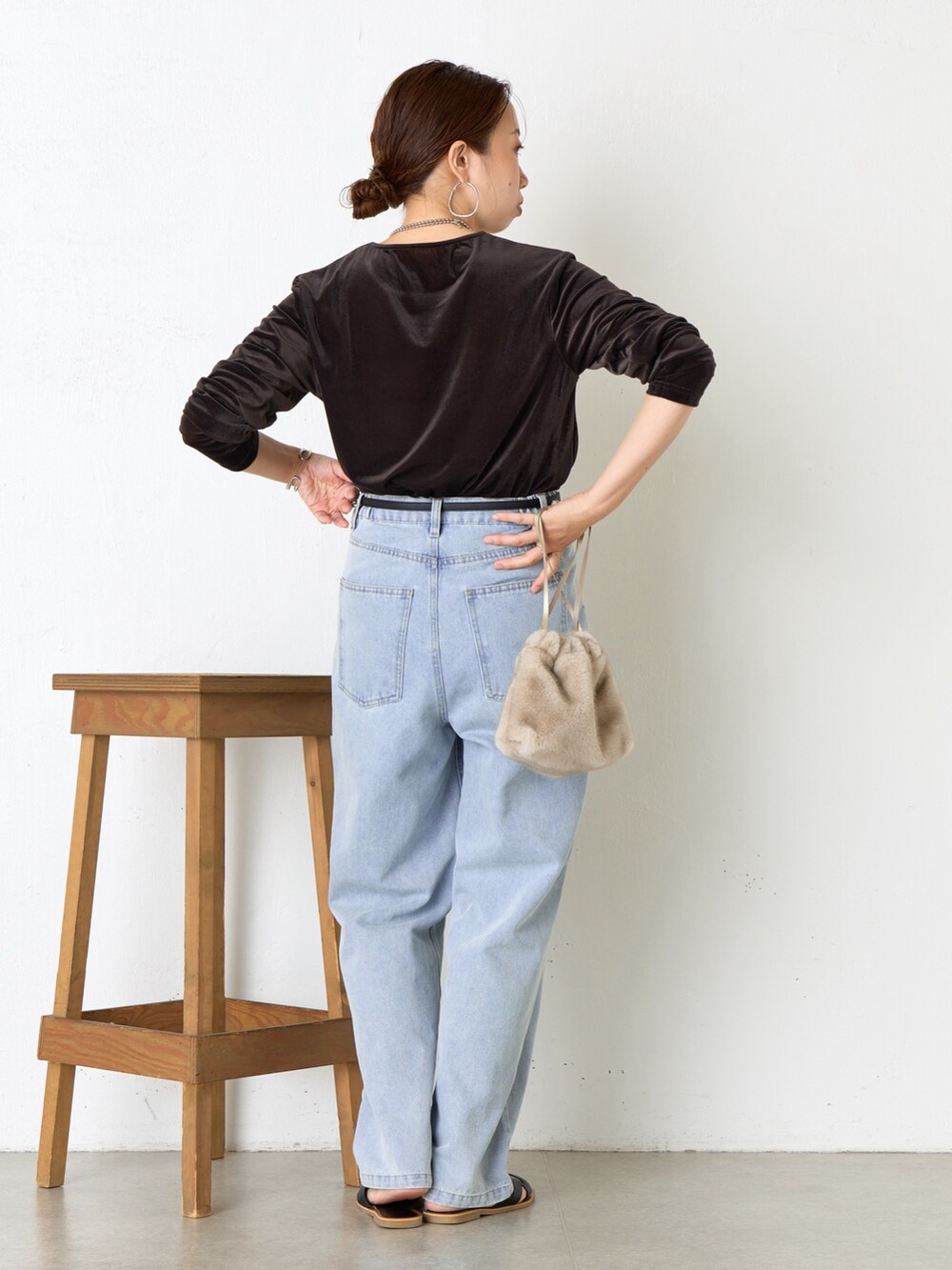 ブラウン系のトートバッグ、ブラック系のサンダル、ブルー系のデニムパンツを着用したレディースの夏コーディネートの3枚目の写真