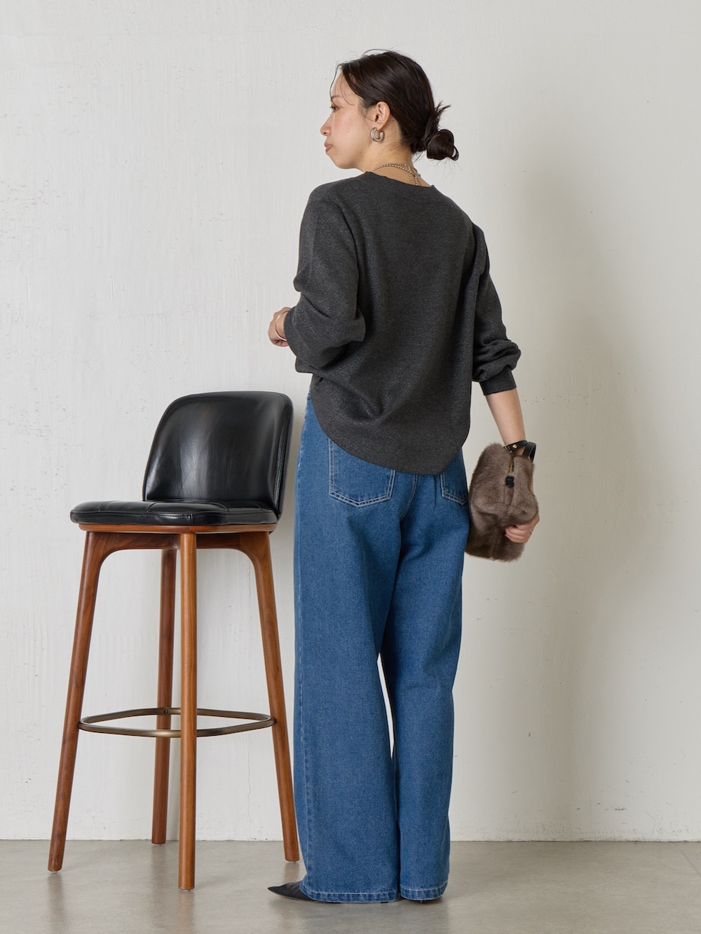 グレー系のニット/セーター、ブルー系のデニムパンツ、グレー系のトートバッグを着用したレディースの秋コーディネートの3枚目の写真