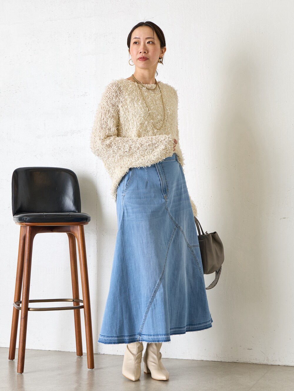 ベージュ系のニット/セーター、ホワイト系のトートバッグを着用したレディースの冬コーディネートの2枚目の写真