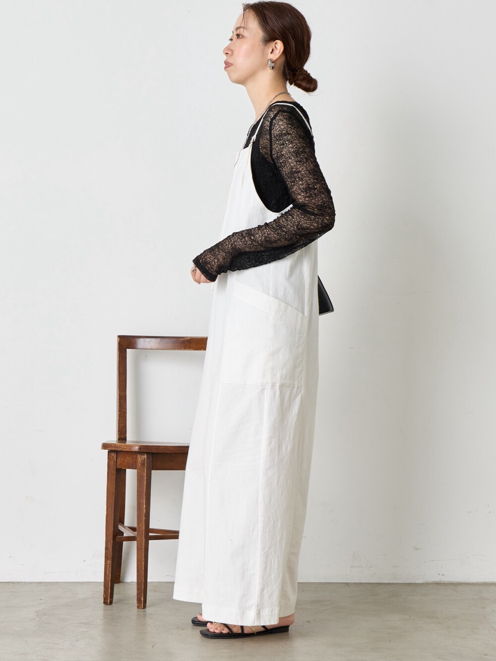 ホワイト系のワンピース、ブラック系のサンダル、ブラック系のショルダーバッグを着用したレディースの夏コーディネートの2枚目の写真