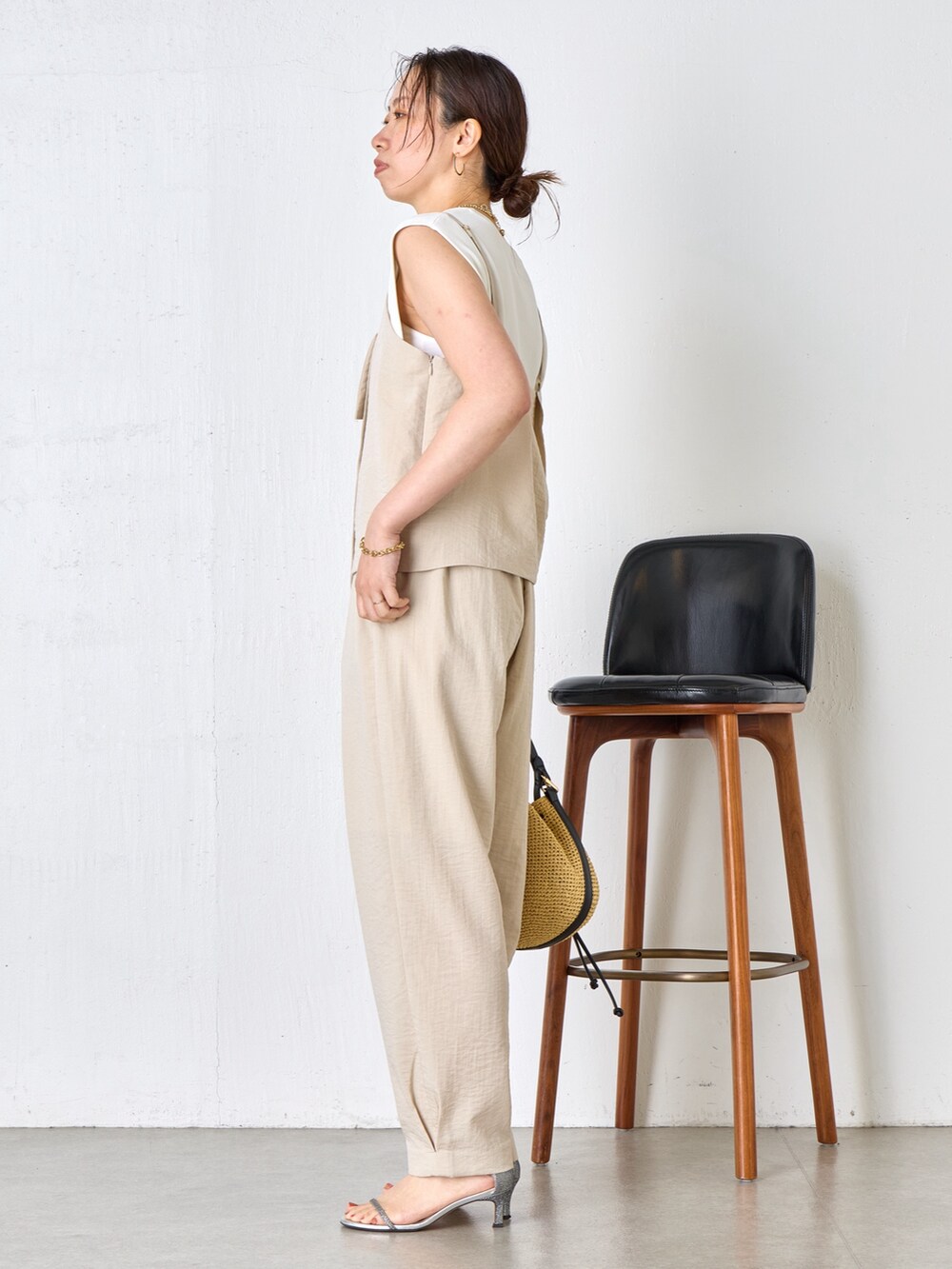 ベージュ系のワンピース、ホワイト系のニット/セーター、ベージュ系のトートバッグを着用したレディースの夏コーディネートの2枚目の写真