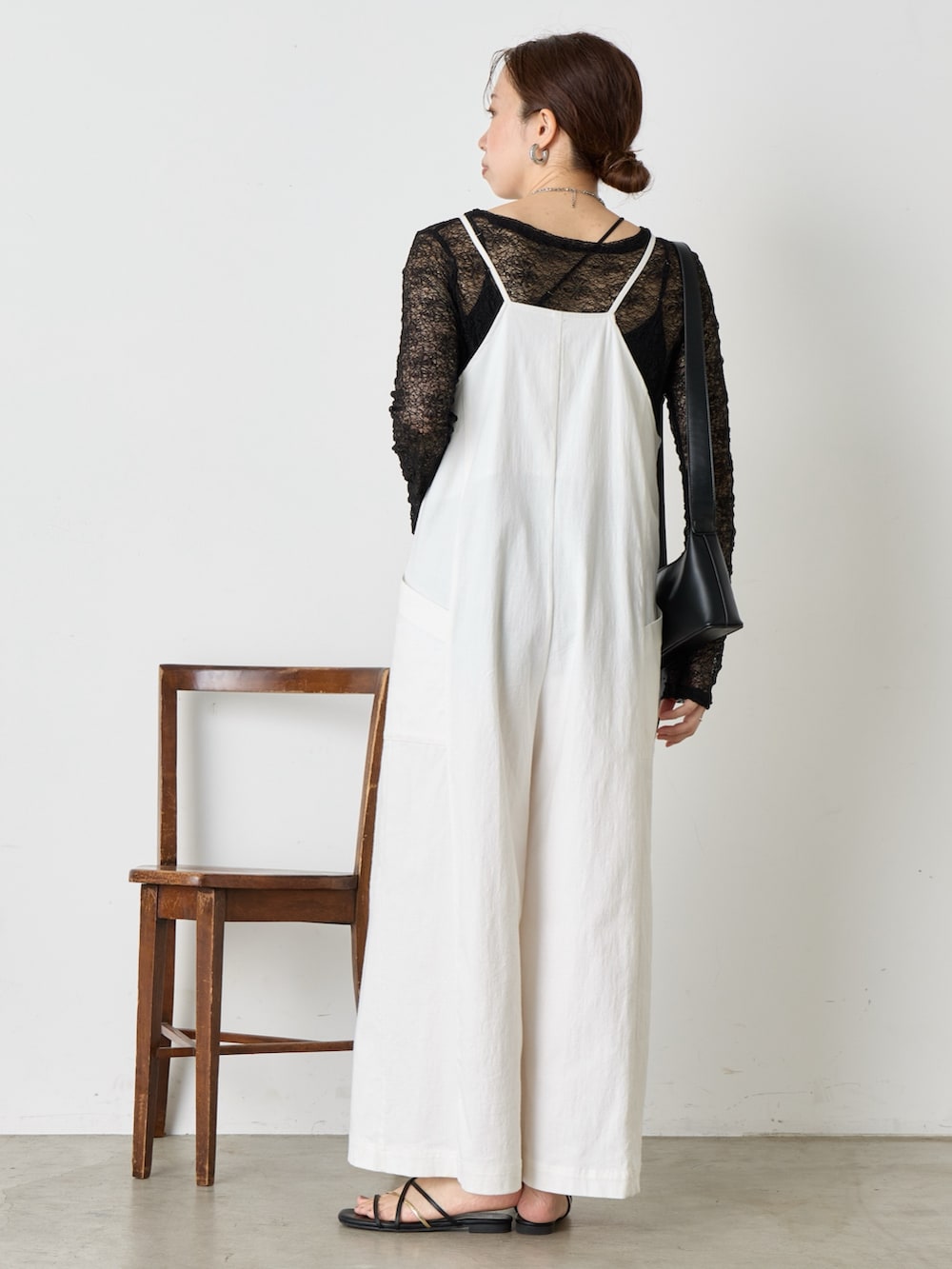 ホワイト系のワンピース、ブラック系のサンダル、ブラック系のショルダーバッグを着用したレディースの夏コーディネートの3枚目の写真