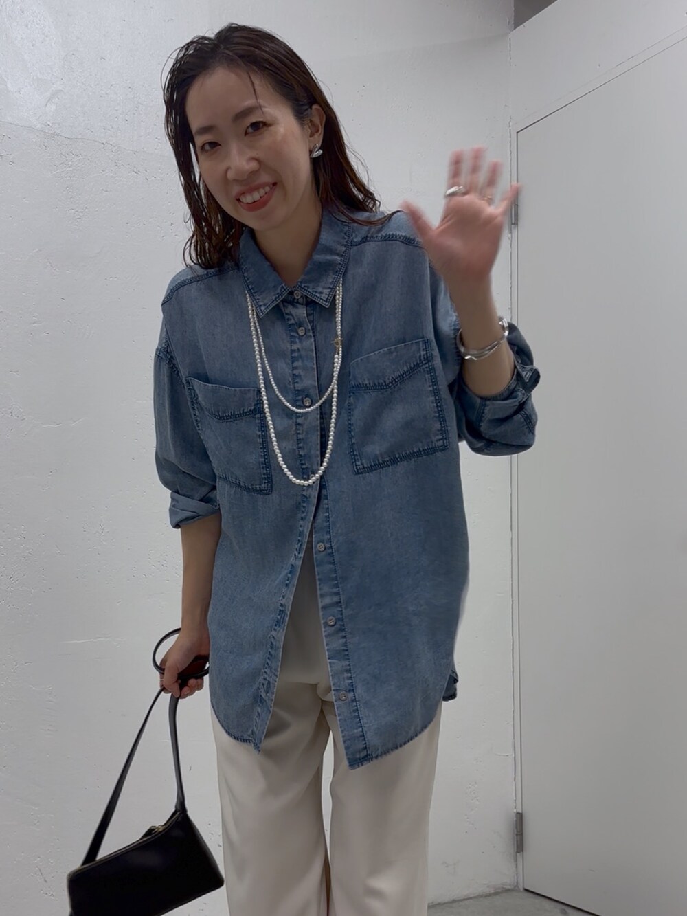 ブルー系のシャツ/ブラウス、ホワイト系のその他パンツ、ブラック系のショルダーバッグを着用したレディースの春コーディネートの5枚目の写真