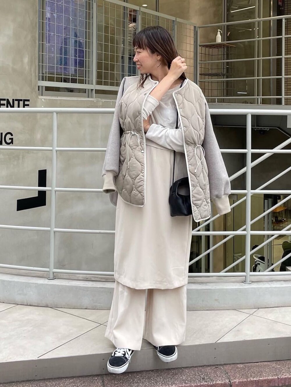 グレー系のその他アウター、ブラック系のショルダーバッグを着用したレディースの秋コーディネートの3枚目の写真