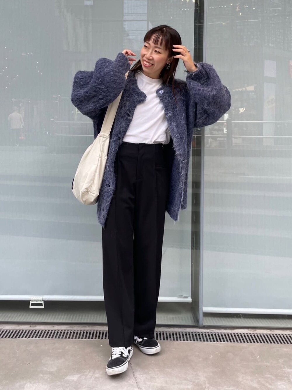 ブルー系のニット/セーター、ホワイト系のショルダーバッグを着用したレディースの秋コーディネートの2枚目の写真