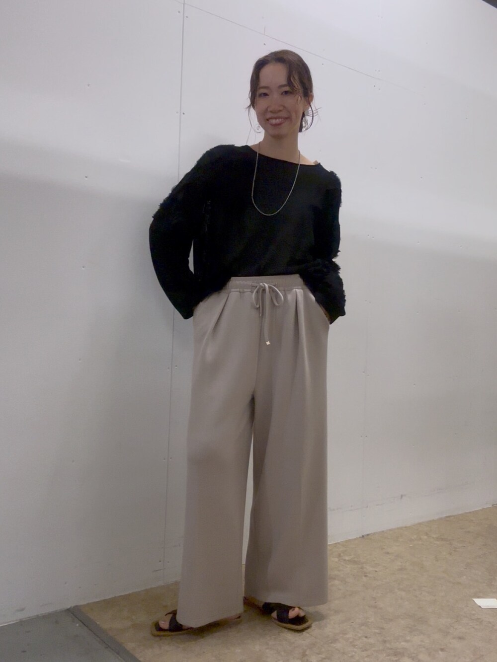 ブラック系のニット/セーター、ブラック系のトートバッグ、ブラック系のサンダルを着用したレディースの夏コーディネートの3枚目の写真