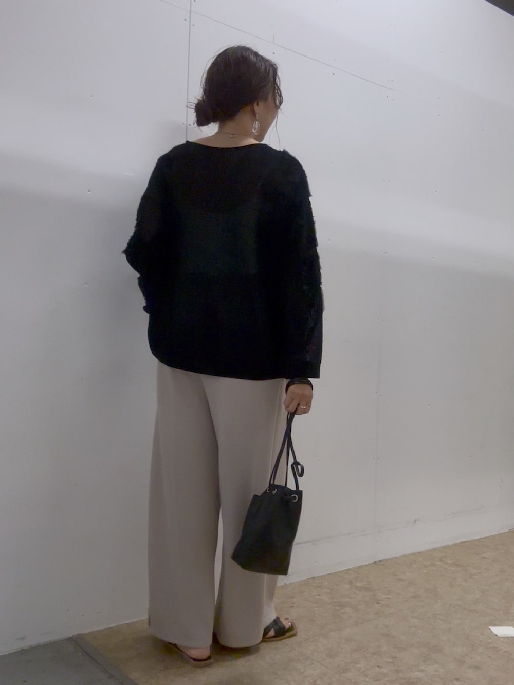 ブラック系のニット/セーター、ブラック系のトートバッグ、ブラック系のサンダルを着用したレディースの夏コーディネートの2枚目の写真