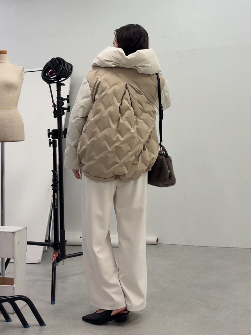 ホワイト系のその他パンツ、ホワイト系のダウンジャケット/コート、グレー系のトートバッグを着用したレディースの秋コーディネートの2枚目の写真