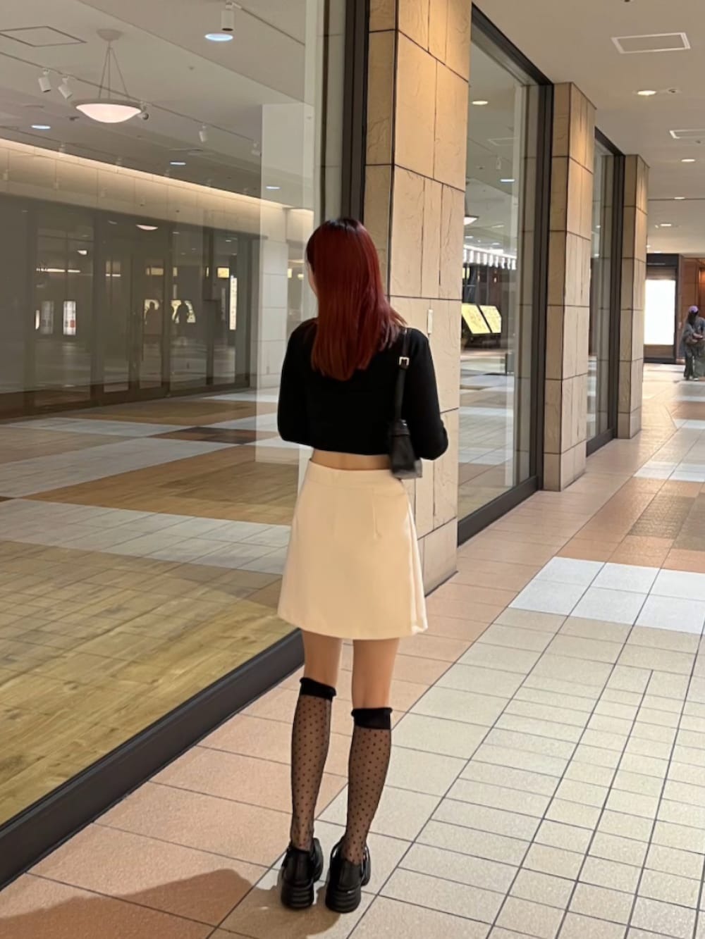 ブラック系のカーディガン/ボレロ、ホワイト系のスカートを着用したレディースの春コーディネートの2枚目の写真