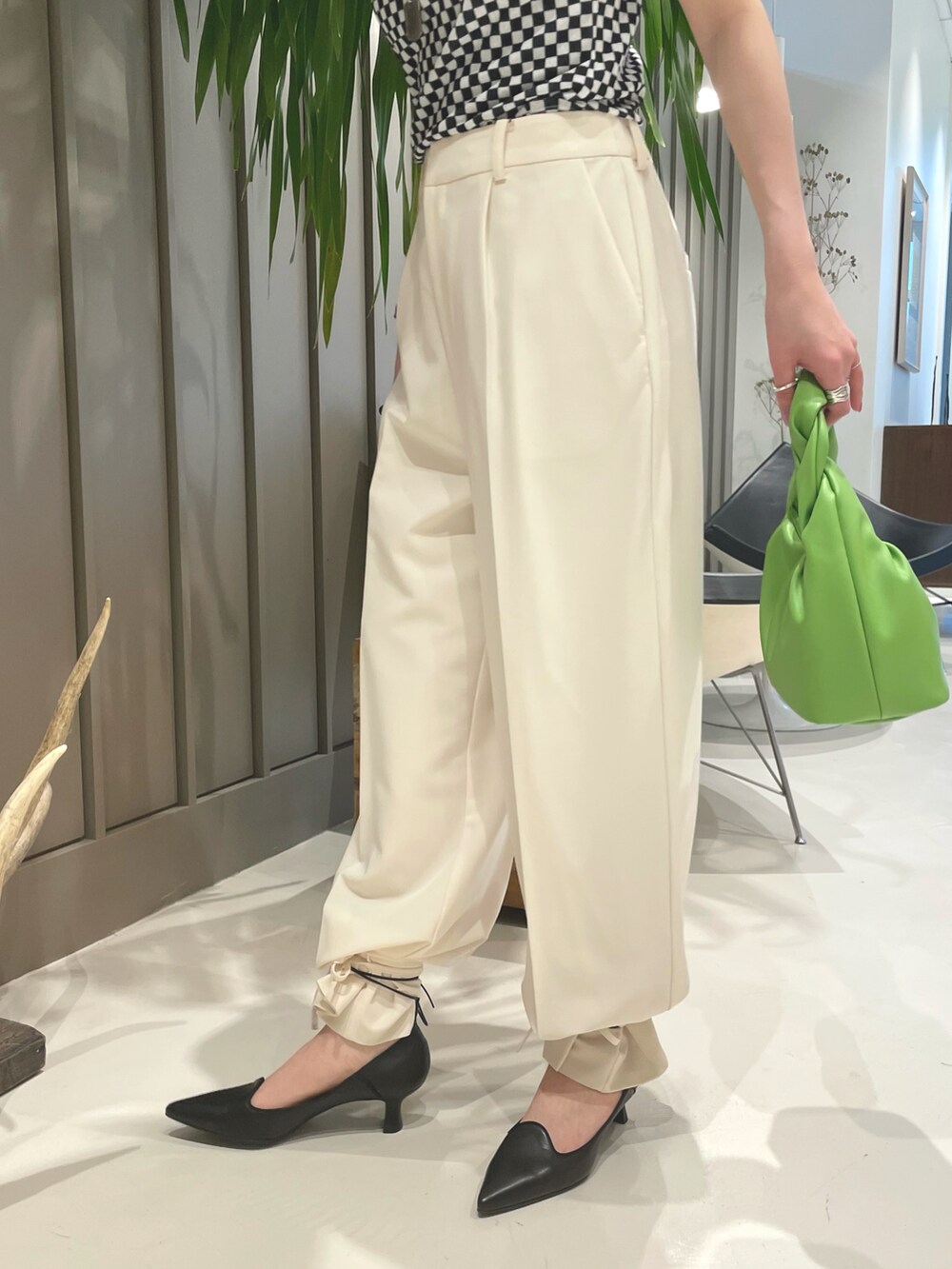 ブラック系のTシャツ/カットソー、グリーン系のトートバッグ、ブラック系のパンプスを着用したレディースの春コーディネートの3枚目の写真