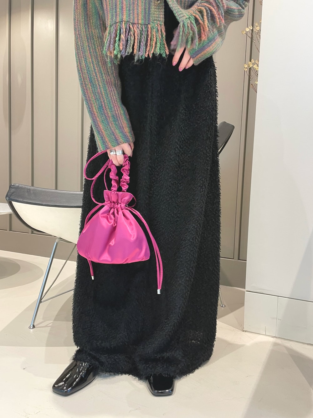 グリーン系のカーディガン/ボレロ、ピンク系のメッセンジャーバッグ、ブラック系のワンピースを着用したレディースの秋コーディネートの4枚目の写真