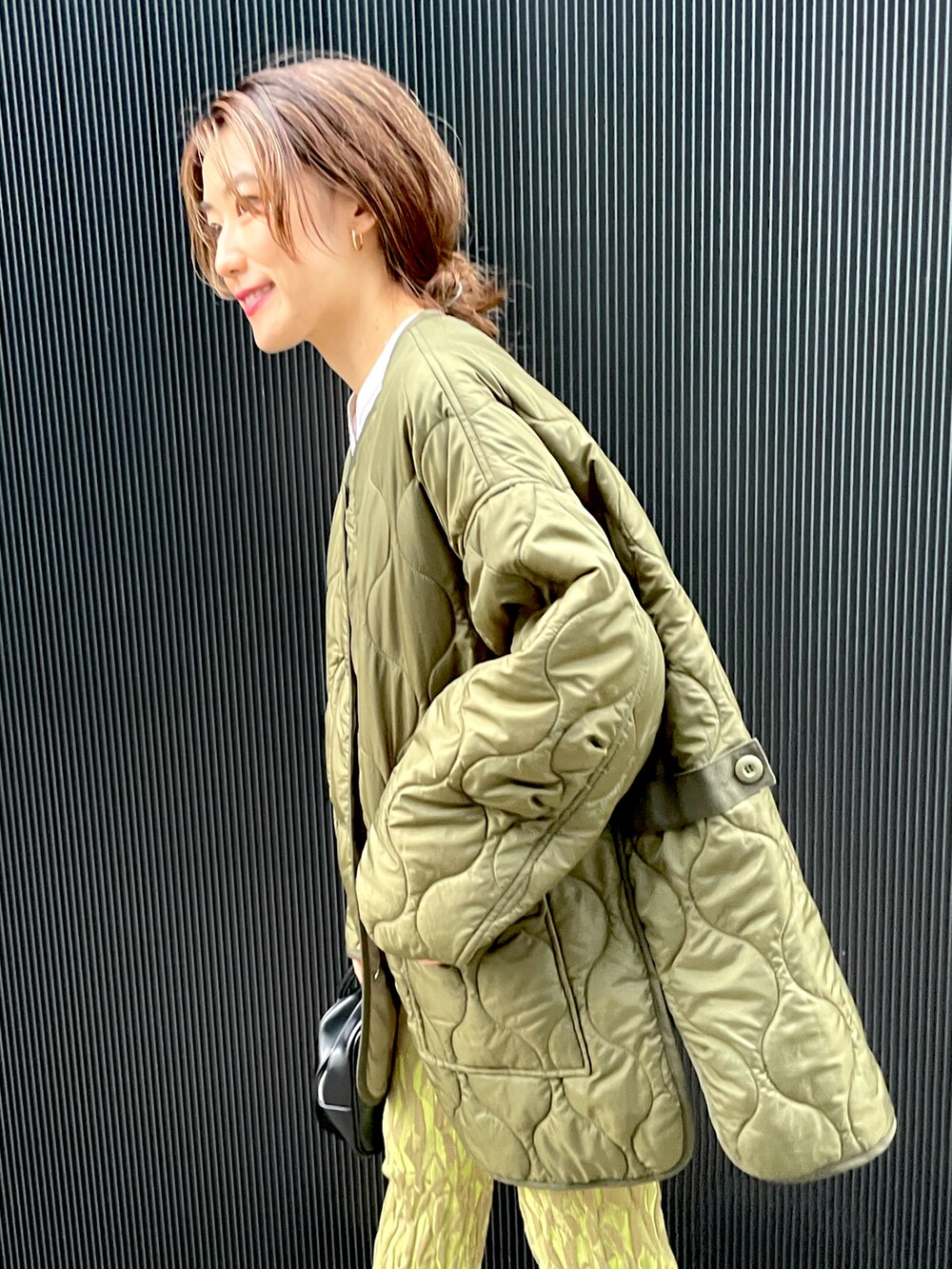 グリーン系のノーカラーコート、グリーン系のその他パンツ、ブラック系のブーツを着用したレディースの秋コーディネートの4枚目の写真