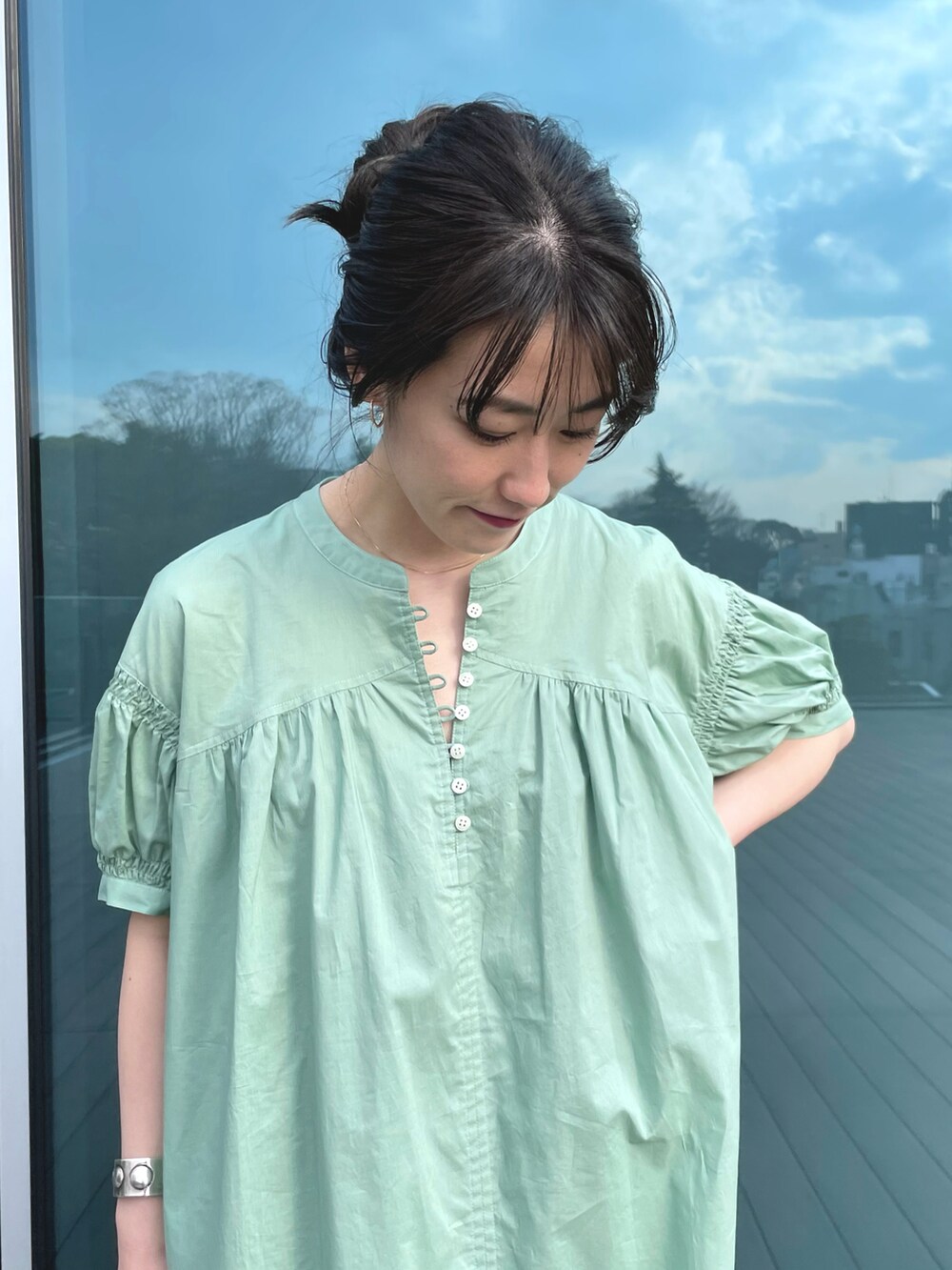 ベージュ系のハンドバッグ、イエロー系のサンダル、グリーン系のワンピースを着用したレディースの春コーディネートの3枚目の写真