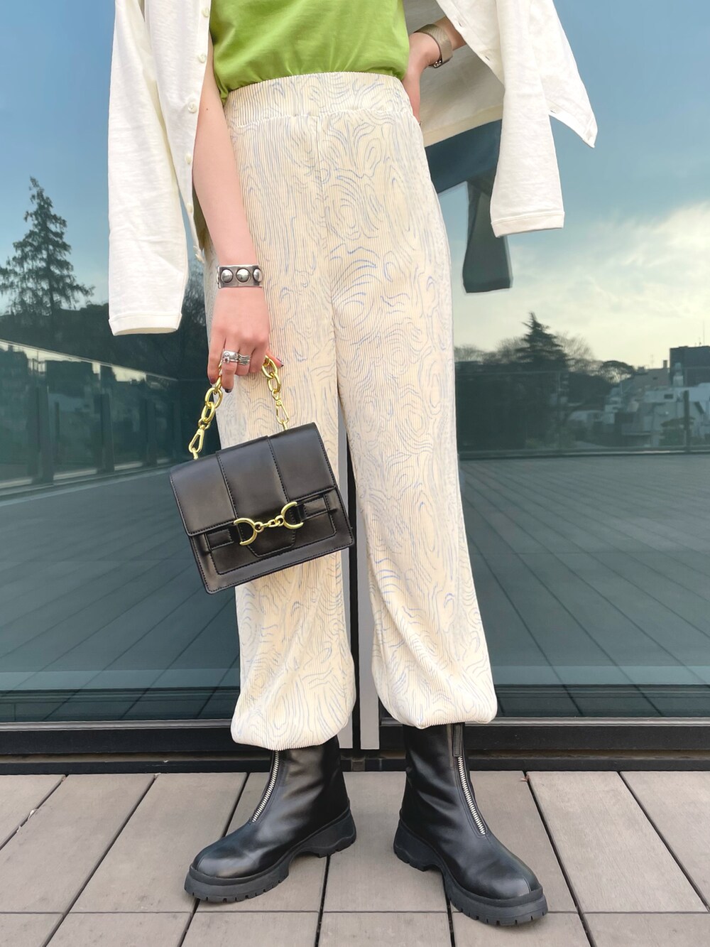 グリーン系のTシャツ/カットソー、ホワイト系のその他パンツ、ブラック系のブーツを着用したレディースの春コーディネートの3枚目の写真