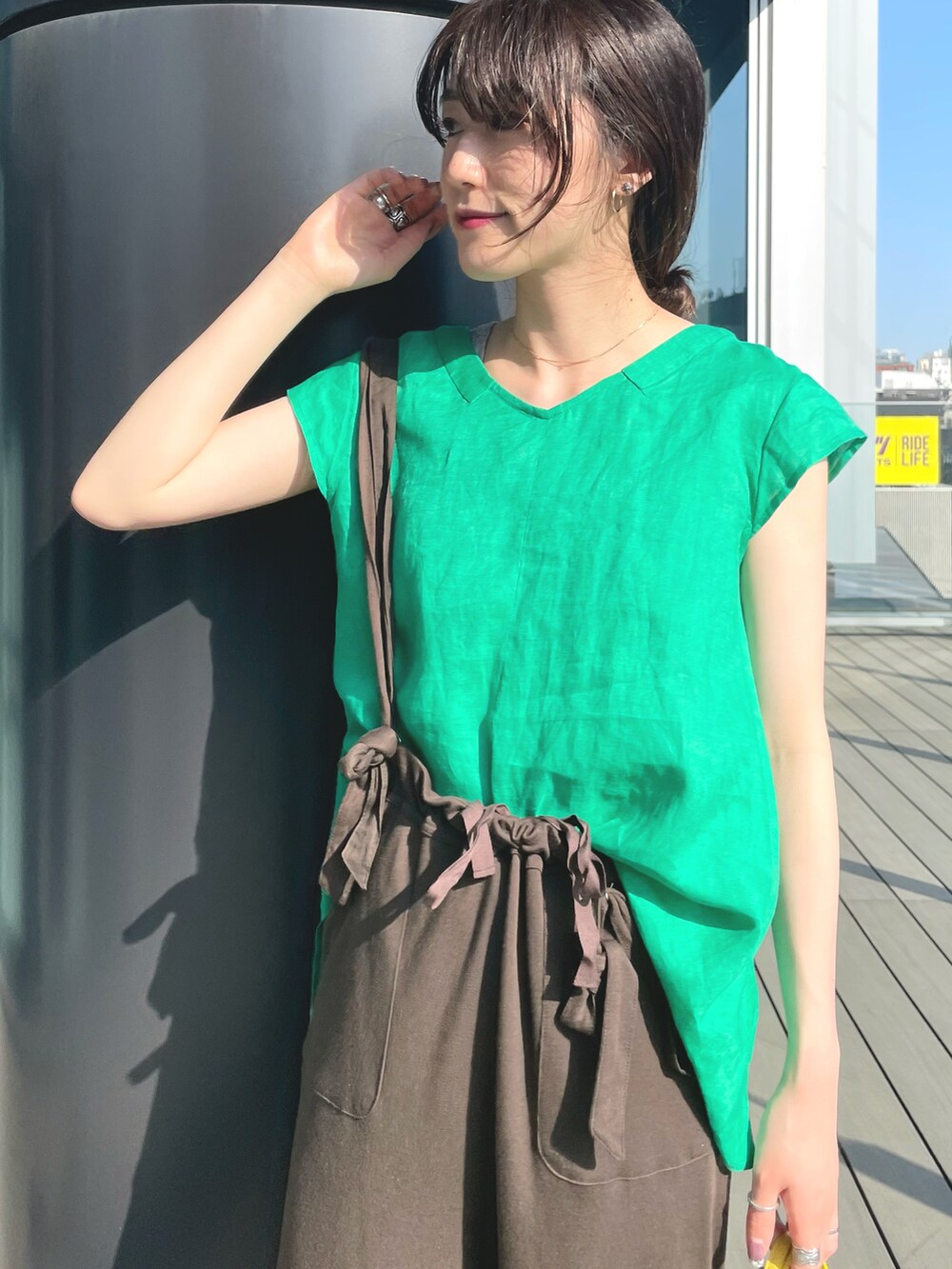 グリーン系のシャツ/ブラウス、ブラウン系のその他パンツ、イエロー系のバッグを着用したレディースの春コーディネートの2枚目の写真