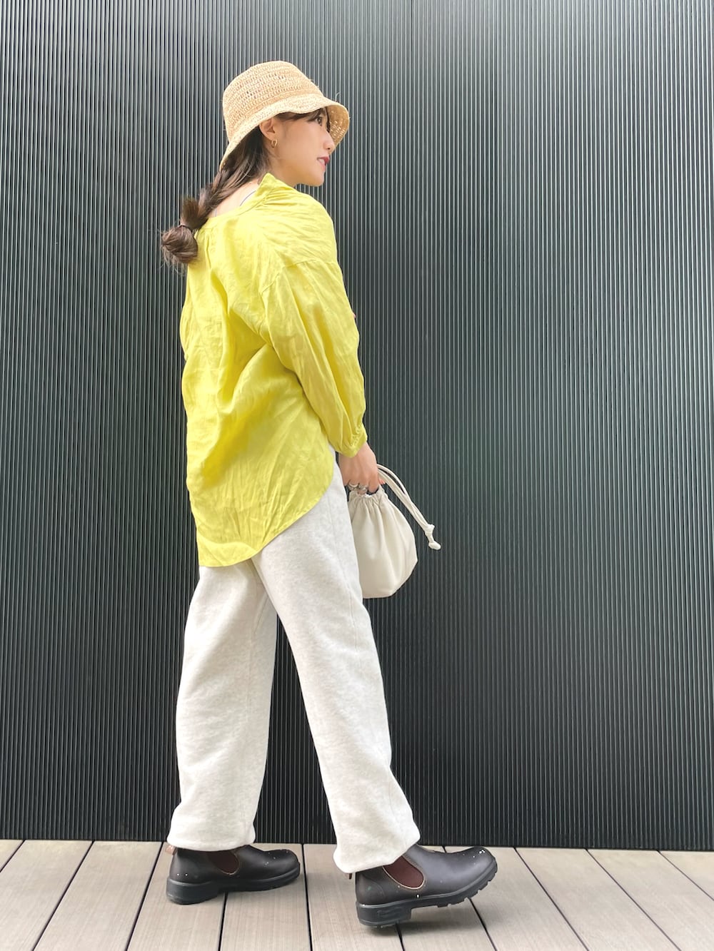 イエロー系のシャツ/ブラウス、ホワイト系のバッグ、ブラウン系のレインシューズを着用したレディースの春コーディネートの2枚目の写真