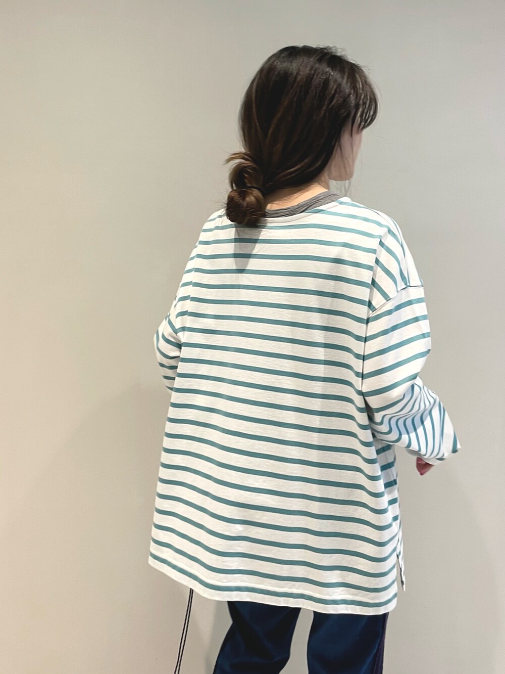 グリーン系のTシャツ/カットソー、グリーン系のトートバッグ、ブルー系のデニムパンツを着用したレディースの春コーディネートの3枚目の写真