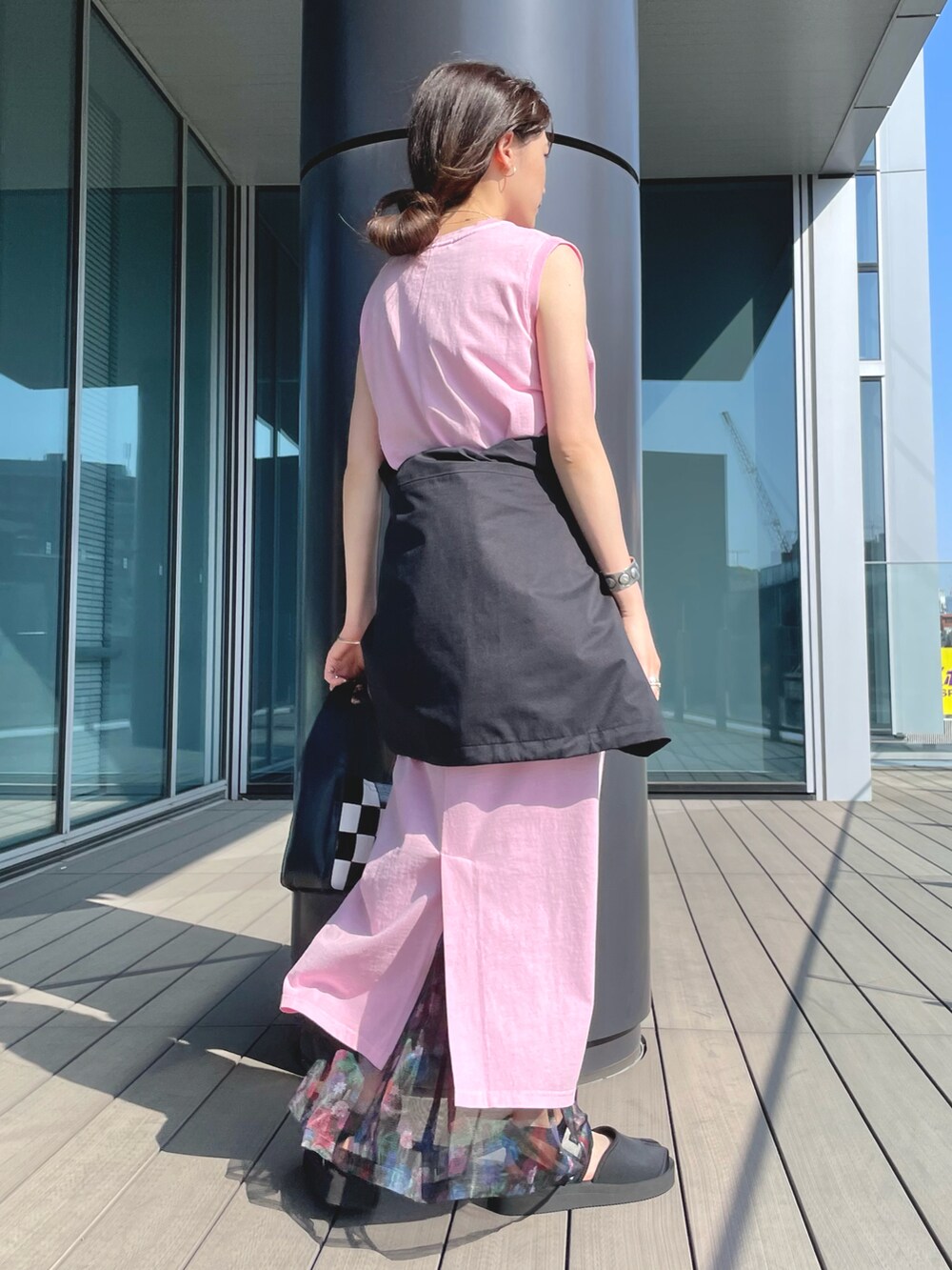 ピンク系のワンピース、ブラック系のその他アウター、ブラック系のハンドバッグを着用したレディースの夏コーディネートの2枚目の写真