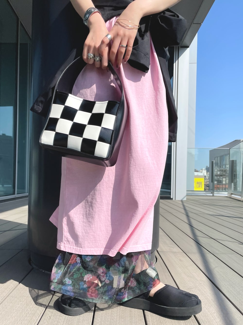 ピンク系のワンピース、ブラック系のその他アウター、ブラック系のハンドバッグを着用したレディースの夏コーディネートの4枚目の写真