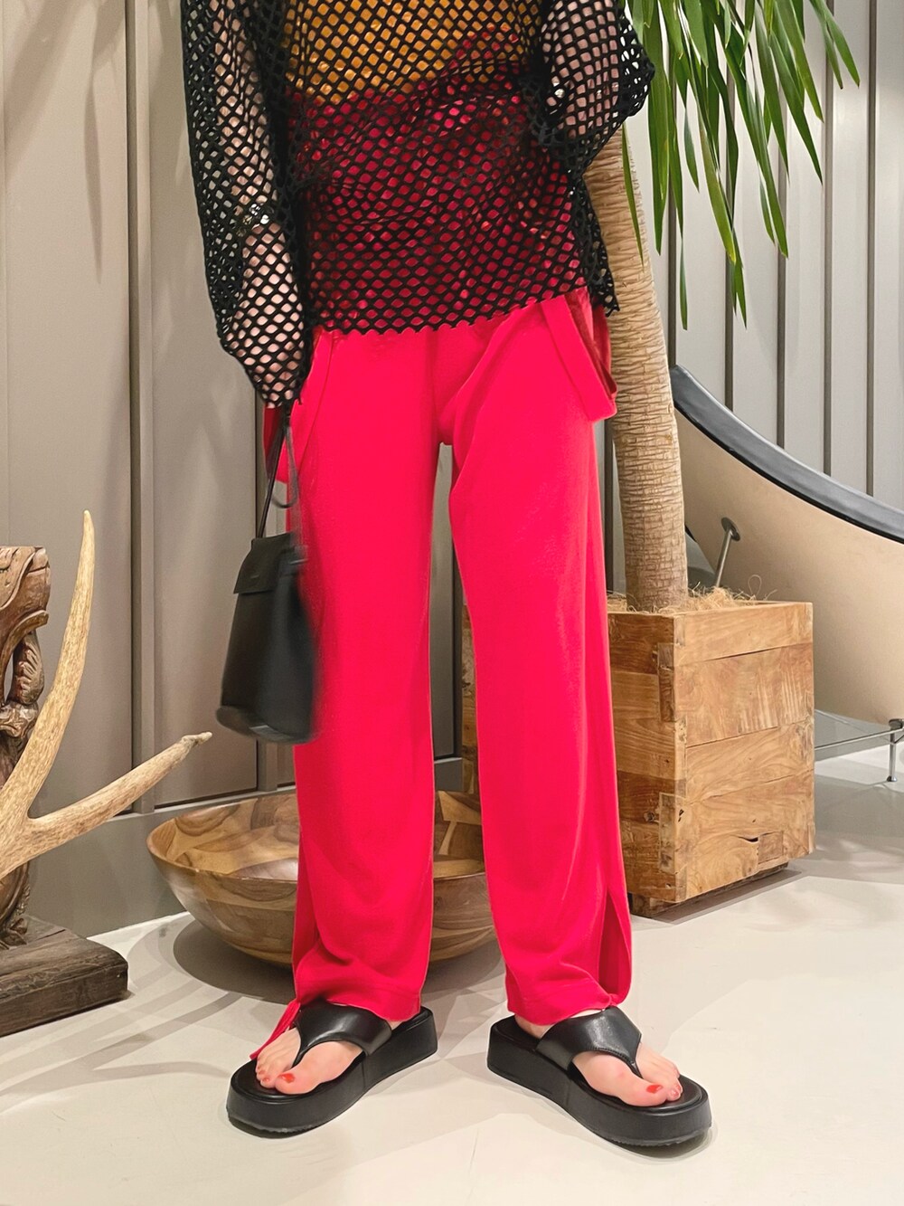 ブラック系のショルダーバッグ、ブラック系のTシャツ/カットソー、レッド系のその他パンツを着用したレディースの冬コーディネートの4枚目の写真