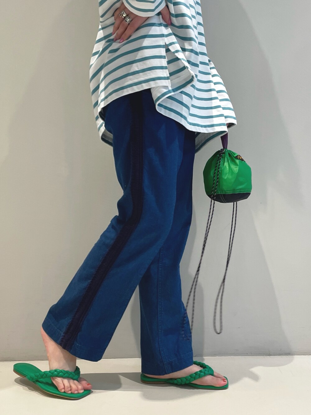 グリーン系のTシャツ/カットソー、グリーン系のトートバッグ、ブルー系のデニムパンツを着用したレディースの春コーディネートの5枚目の写真