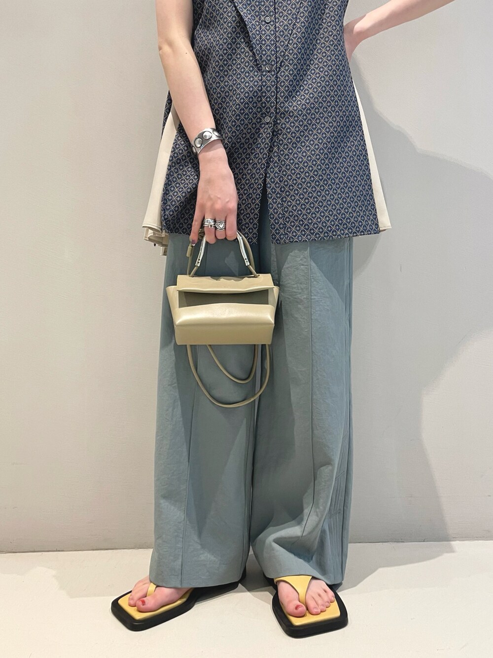 グリーン系のその他パンツ、ブルー系のシャツ/ブラウス、レッド系のショルダーバッグを着用したレディースの春コーディネートの3枚目の写真