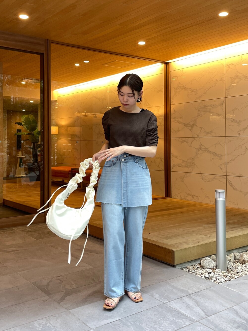 ブラウン系のTシャツ/カットソー、ブルー系のデニムパンツ、その他のサンダルを着用したレディースの夏コーディネートの4枚目の写真