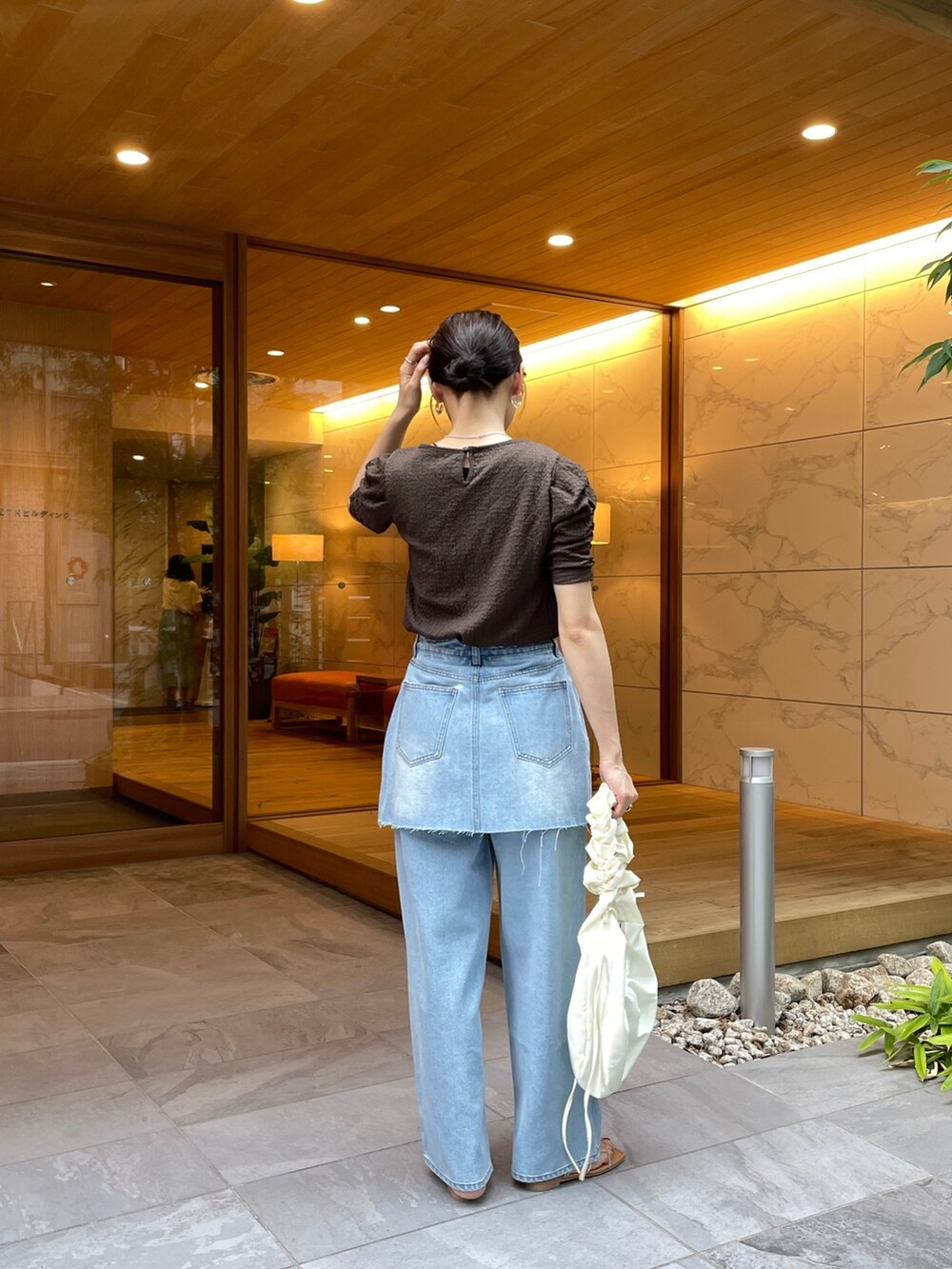 ブラウン系のTシャツ/カットソー、ブルー系のデニムパンツ、その他のサンダルを着用したレディースの夏コーディネートの3枚目の写真