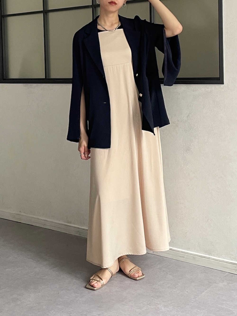 ブルー系のテーラードジャケット、ベージュ系のワンピース、ゴールド系のサンダルを着用したレディースの夏コーディネートの2枚目の写真