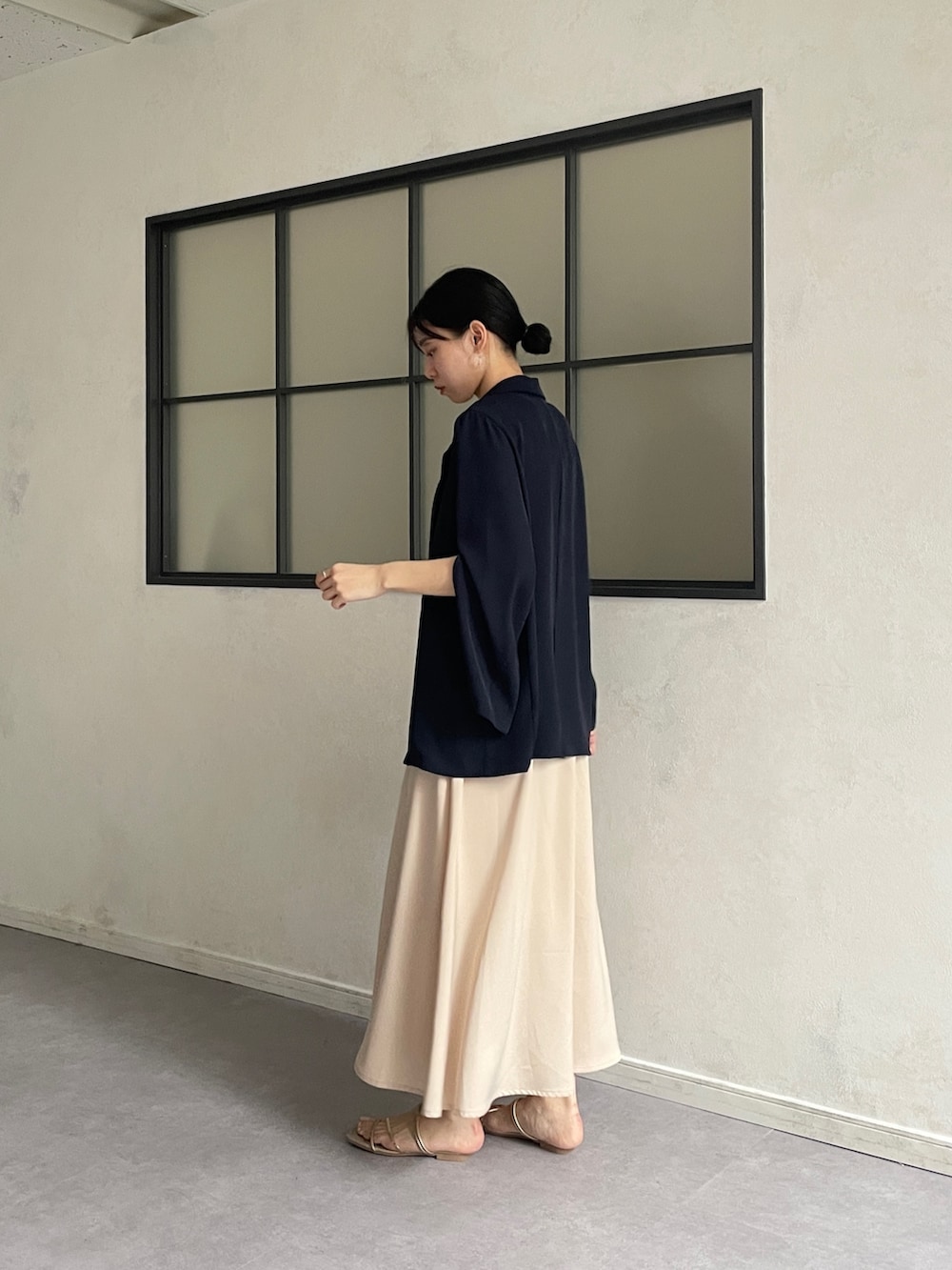 ブルー系のテーラードジャケット、ベージュ系のワンピース、ゴールド系のサンダルを着用したレディースの夏コーディネートの3枚目の写真