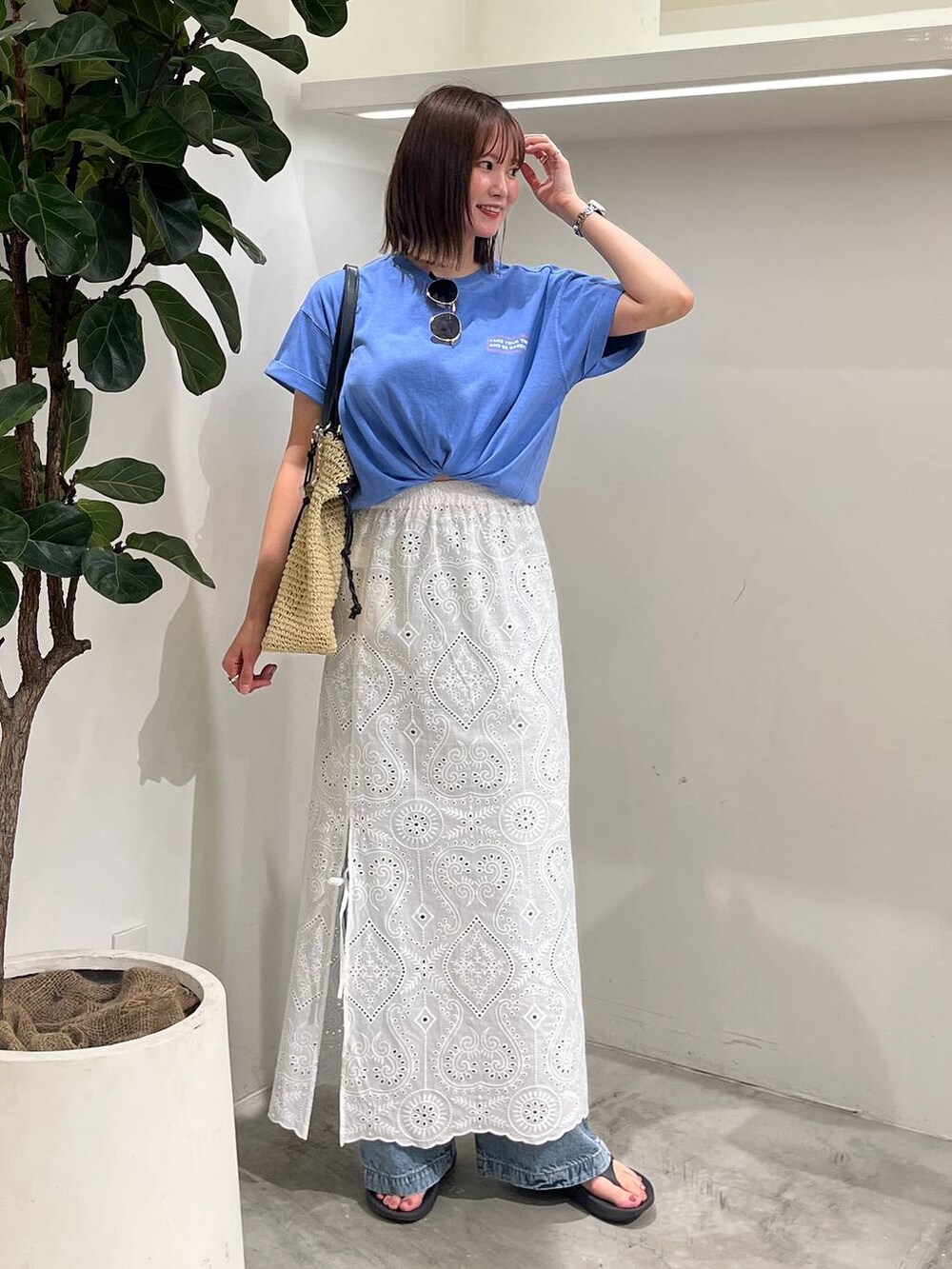 ブルー系のTシャツ/カットソー、ベージュ系のトートバッグ、ブルー系のデニムパンツを着用したレディースの夏コーディネートの3枚目の写真