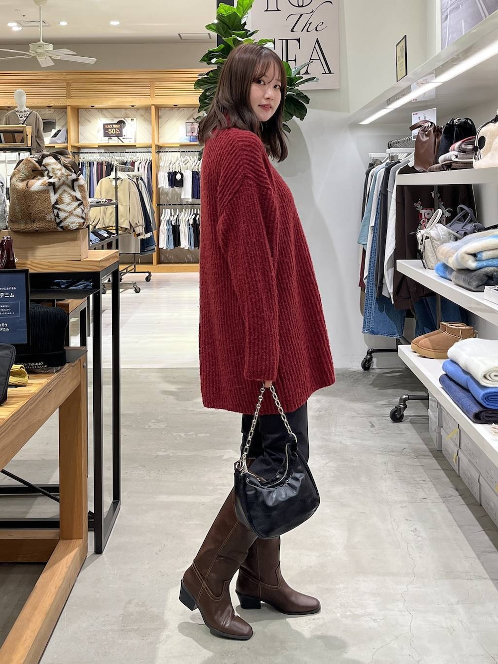 ブラック系のその他パンツ、ブラウン系のブーツ、レッド系のチュニックを着用したレディースの冬コーディネートの3枚目の写真