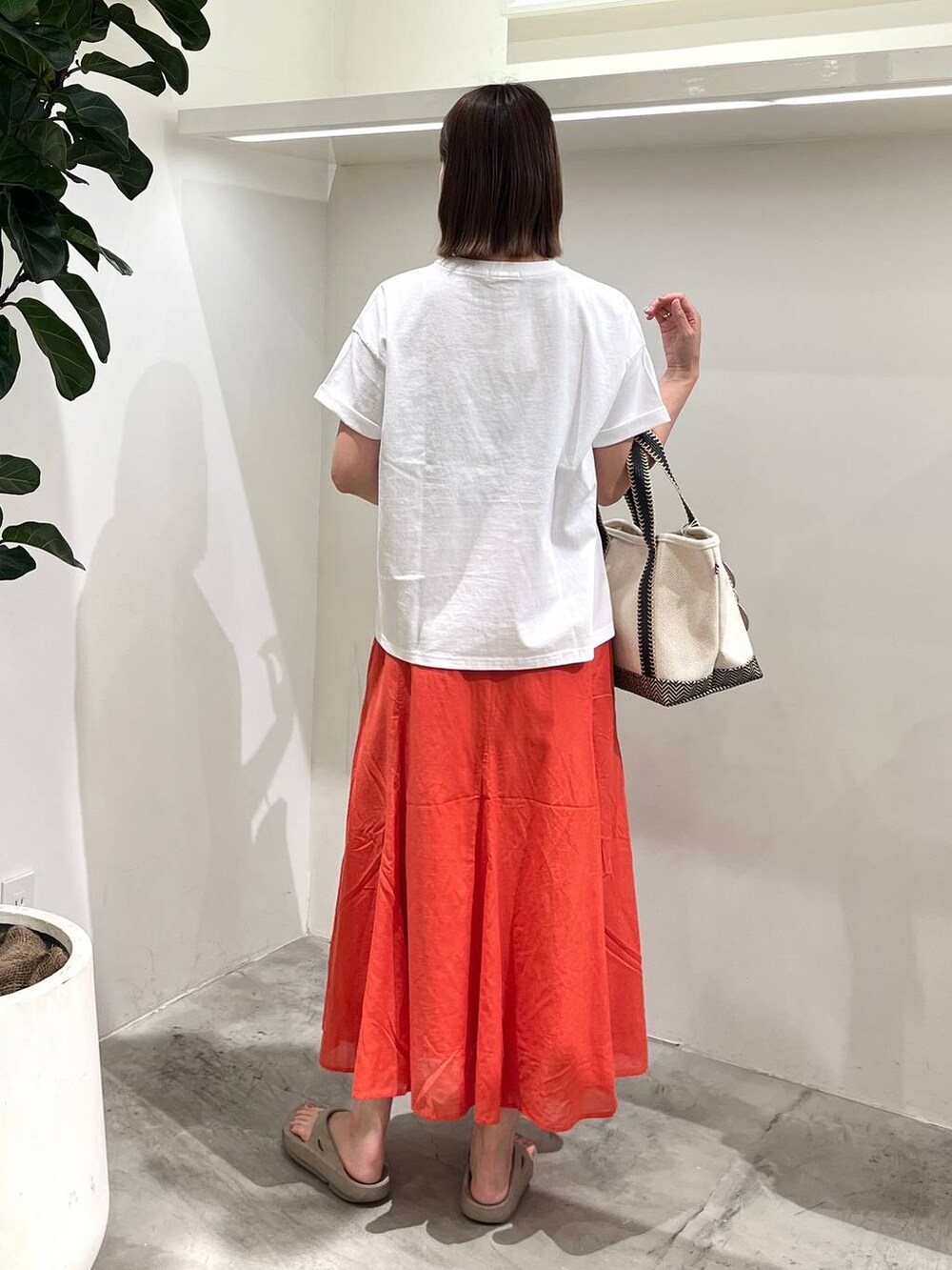 ホワイト系のTシャツ/カットソー、ベージュ系のトートバッグ、ベージュ系のサンダルを着用したレディースの春コーディネートの3枚目の写真