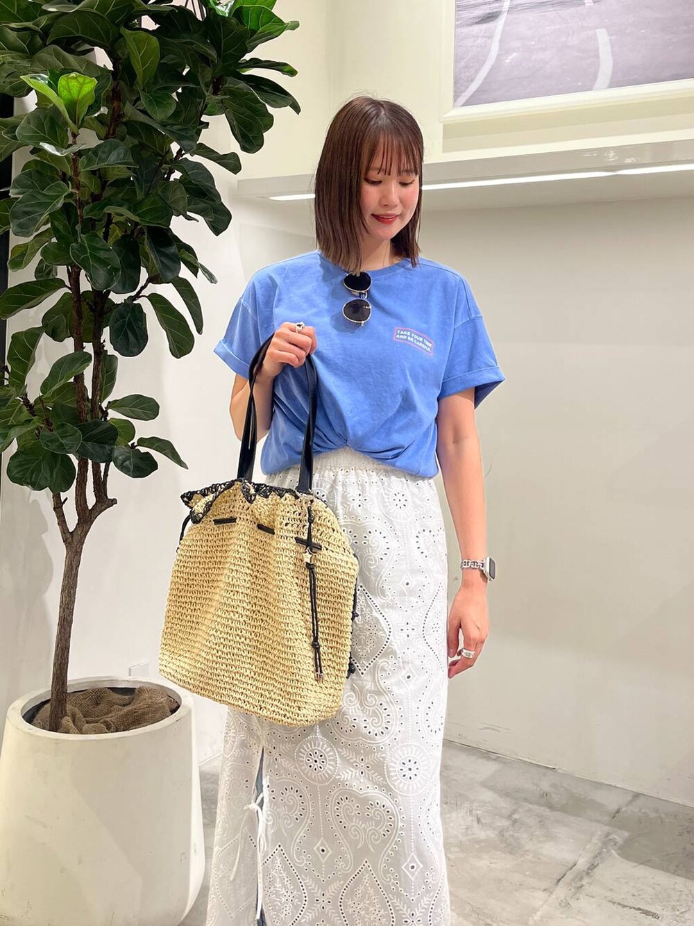 ブルー系のTシャツ/カットソー、ベージュ系のトートバッグ、ブルー系のデニムパンツを着用したレディースの夏コーディネートの2枚目の写真