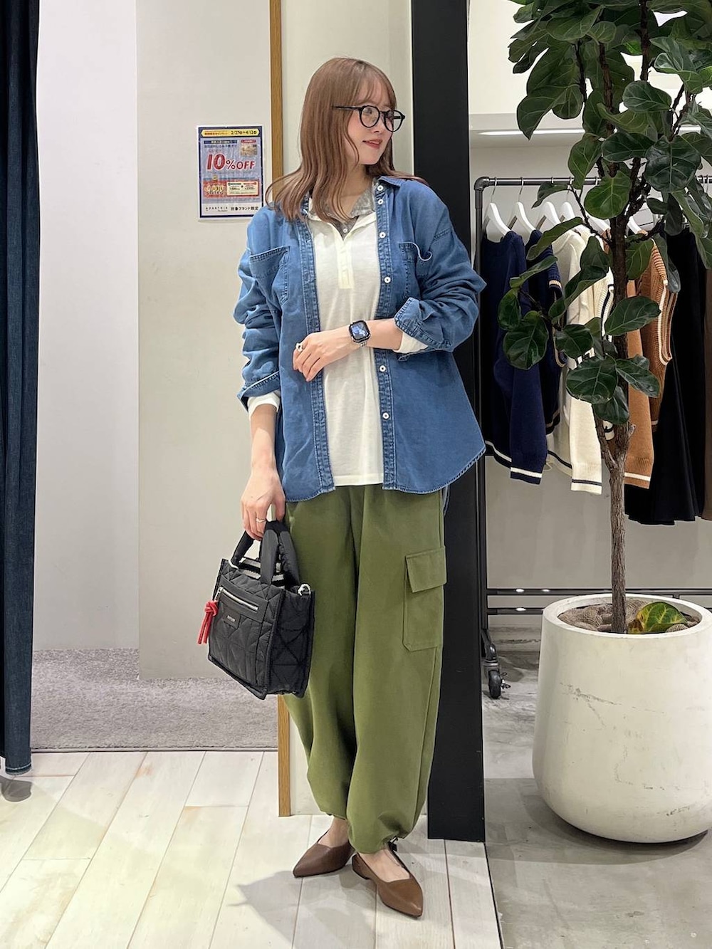 ブラック系のショルダーバッグ、ブルー系のシャツ/ブラウス、グリーン系のカーゴパンツを着用したレディースの春コーディネートの2枚目の写真