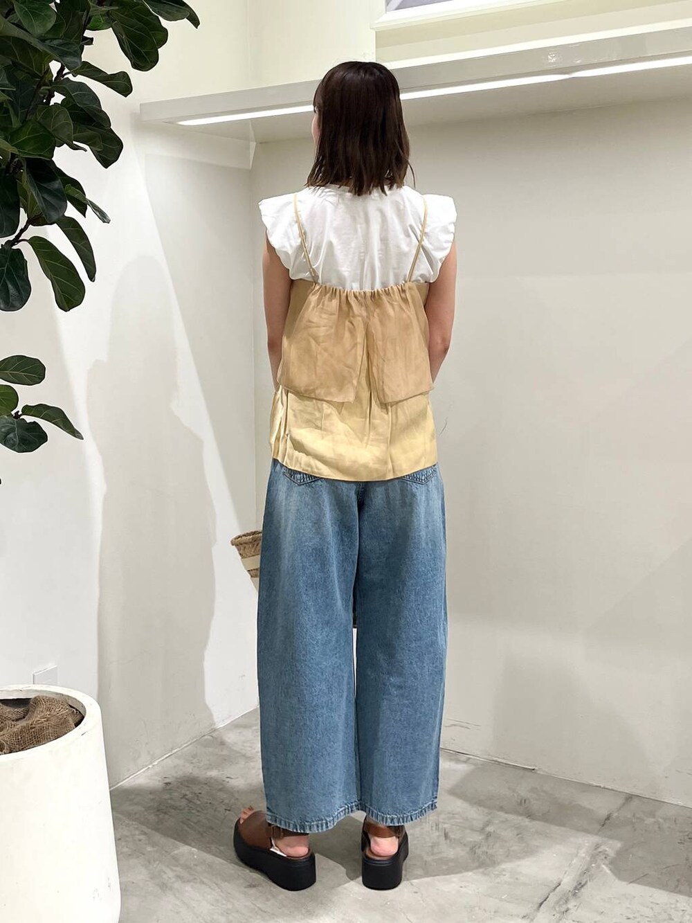 ホワイト系のかごバッグ、ブルー系のデニムパンツ、ホワイト系のTシャツ/カットソーを着用したレディースの夏コーディネートの3枚目の写真