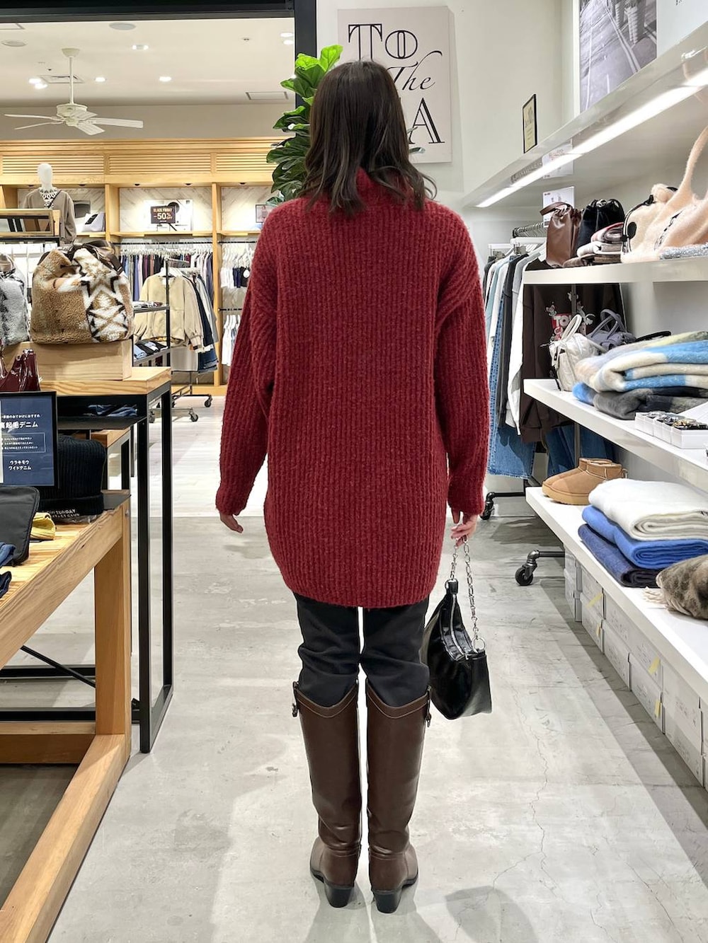 ブラック系のその他パンツ、ブラウン系のブーツ、レッド系のチュニックを着用したレディースの冬コーディネートの4枚目の写真