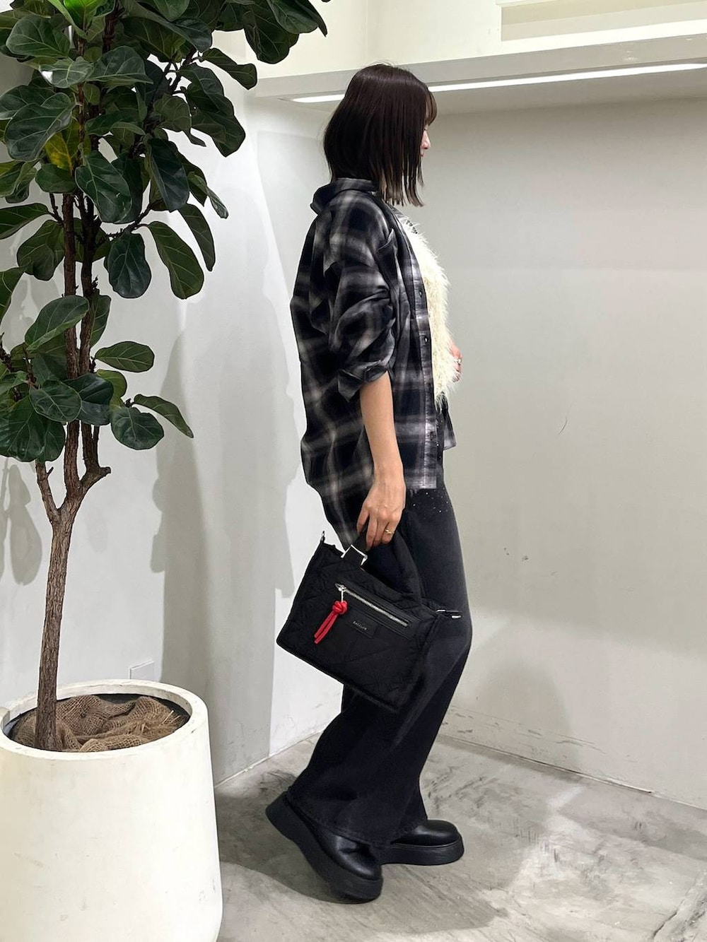 ブラック系のショルダーバッグ、ブラック系のシャツ/ブラウス、ブラック系のデニムパンツを着用したレディースの秋コーディネートの3枚目の写真
