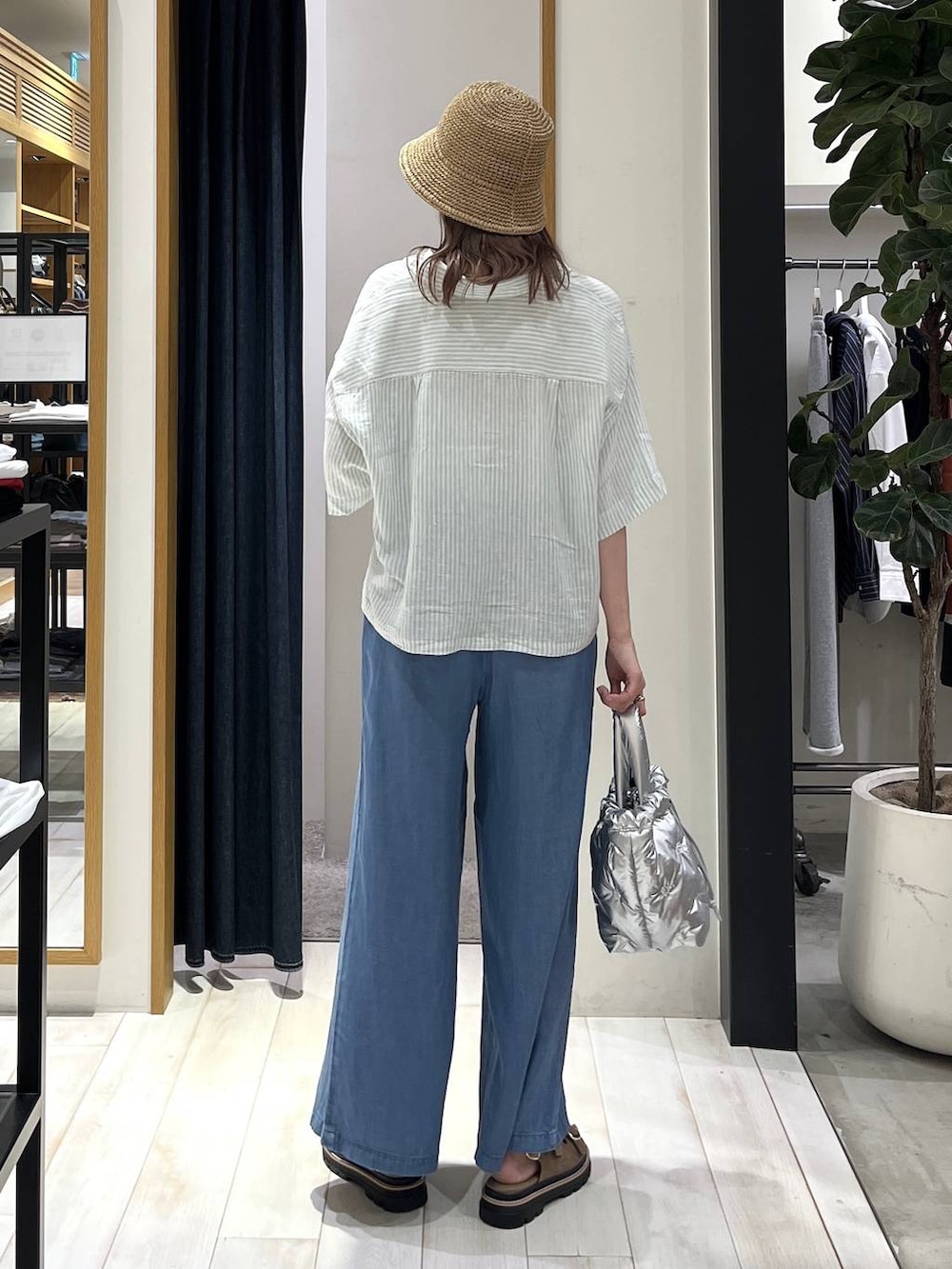 ブルー系のデニムパンツ、シルバー系のショルダーバッグ、ベージュ系のサンダルを着用したレディースの春コーディネートの4枚目の写真
