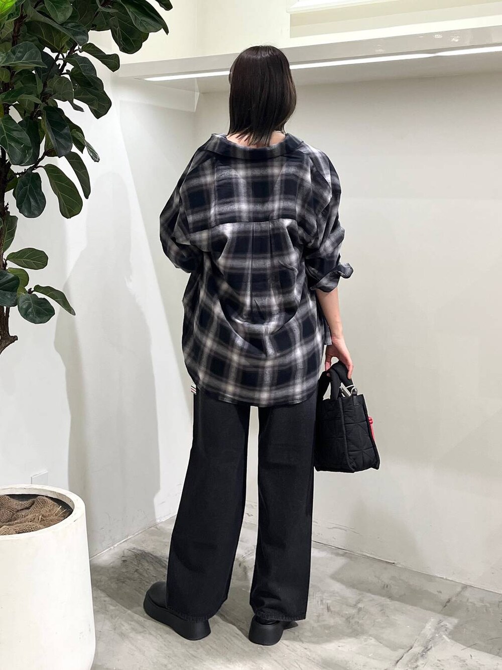 ブラック系のショルダーバッグ、ブラック系のシャツ/ブラウス、ブラック系のデニムパンツを着用したレディースの秋コーディネートの4枚目の写真