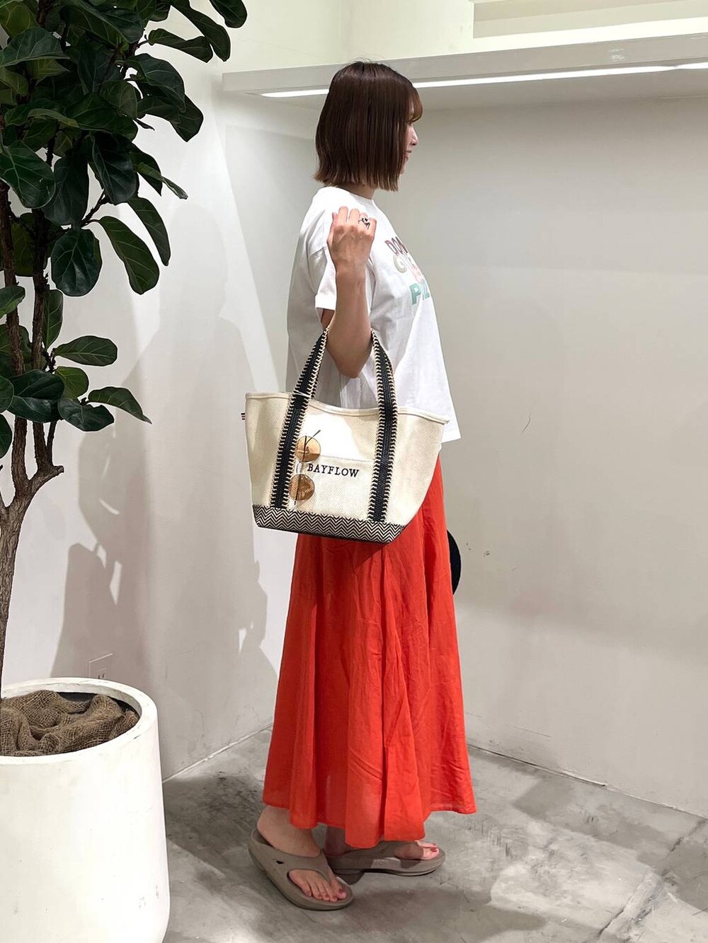 ホワイト系のTシャツ/カットソー、ベージュ系のトートバッグ、ベージュ系のサンダルを着用したレディースの春コーディネートの2枚目の写真